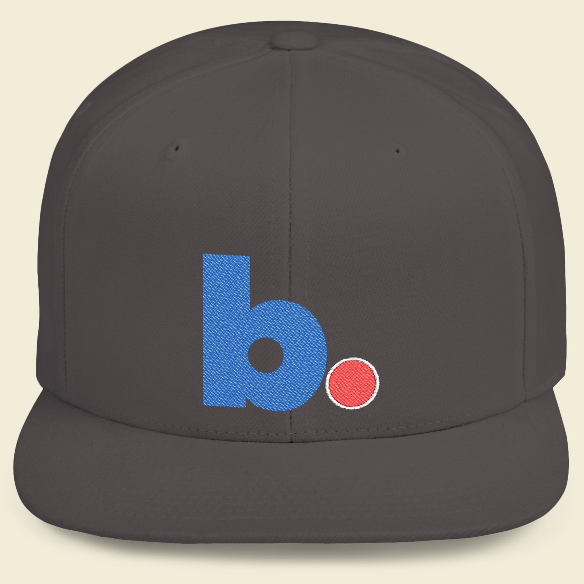 Gray cap with a blue 'b.' logo on a beige background.