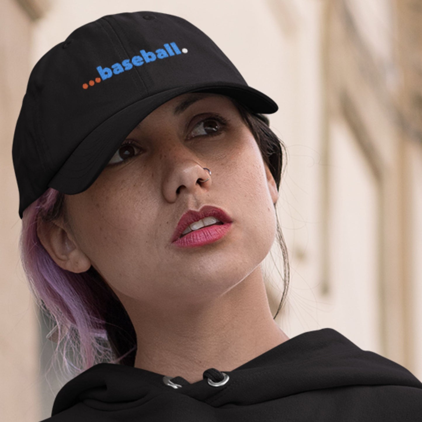 Person wearing a black cap with 'baseball' text, looking to the side.