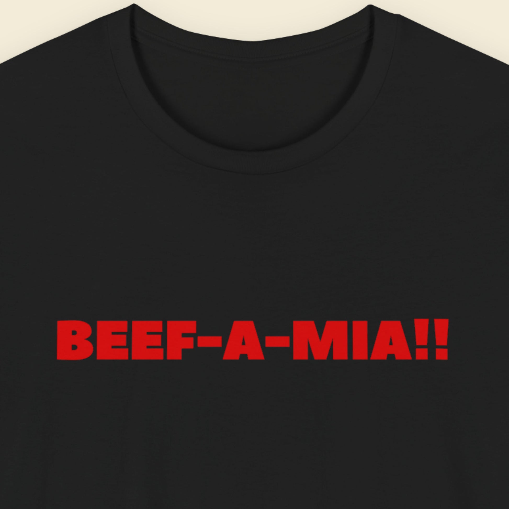 Black t-shirt with humorous colorful text on a beige background.