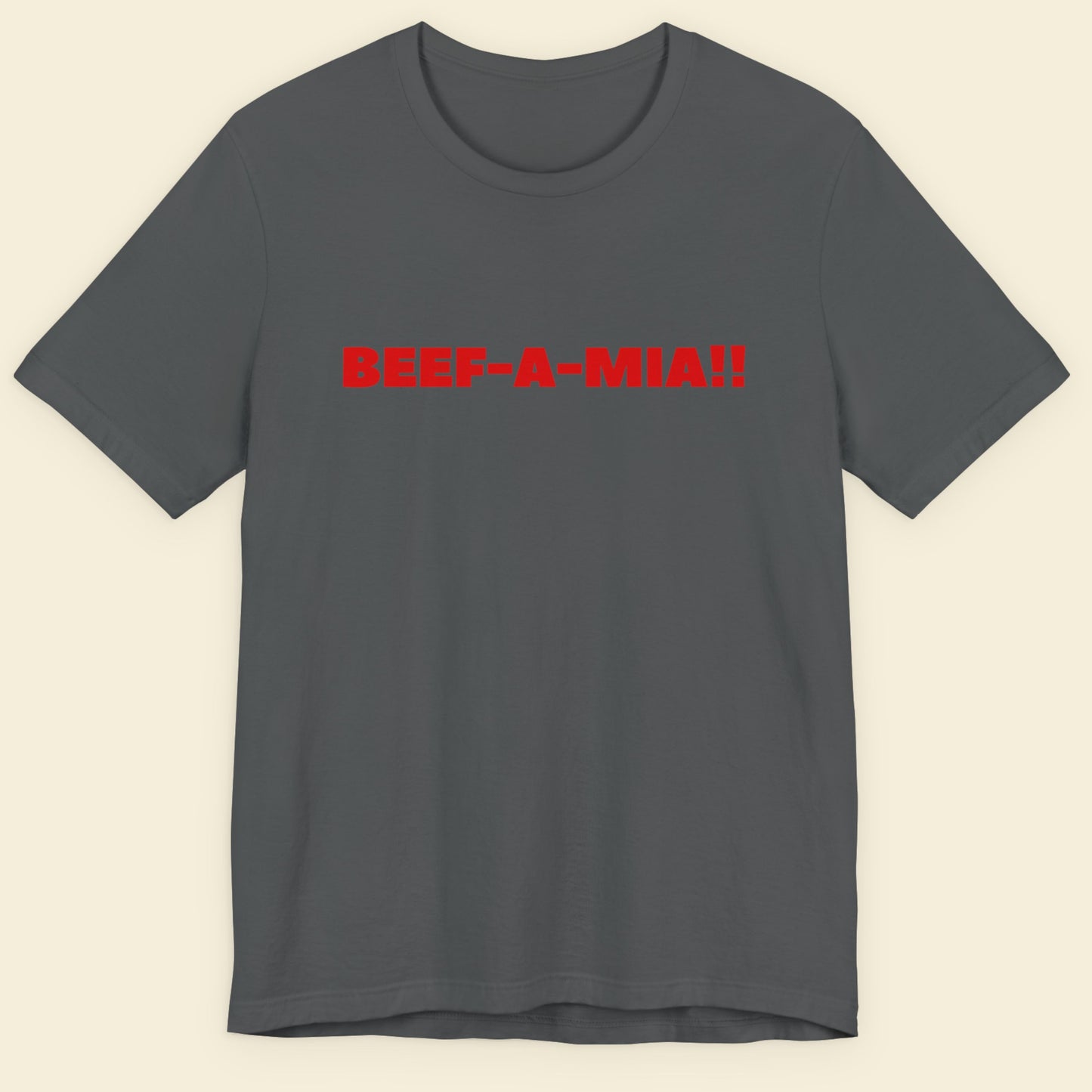 Grey t-shirt with humorous colorful text on a beige background.
