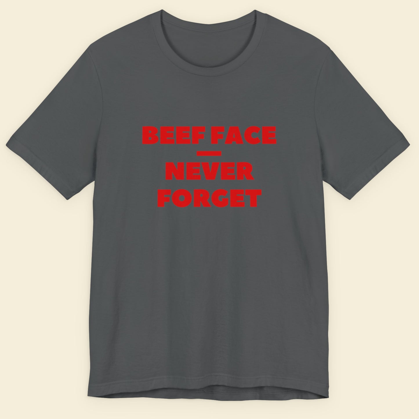 Gray t-shirt with red text 'BEEF FACE NEVER FORGET' on a beige background.