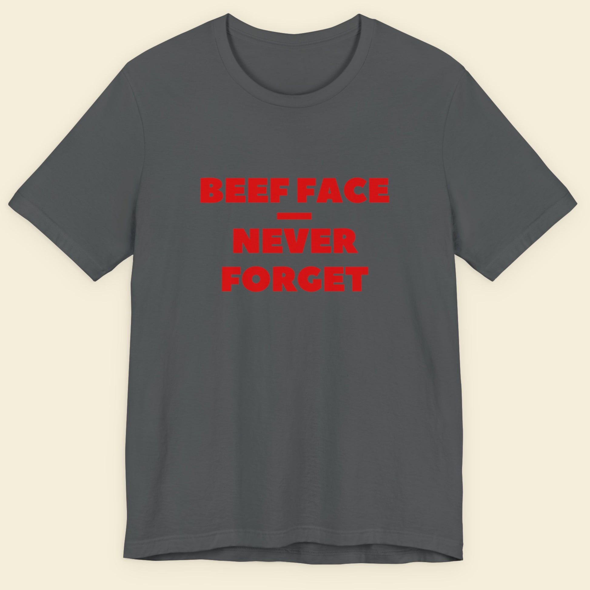 Gray t-shirt with red text 'BEEF FACE NEVER FORGET' on a beige background.