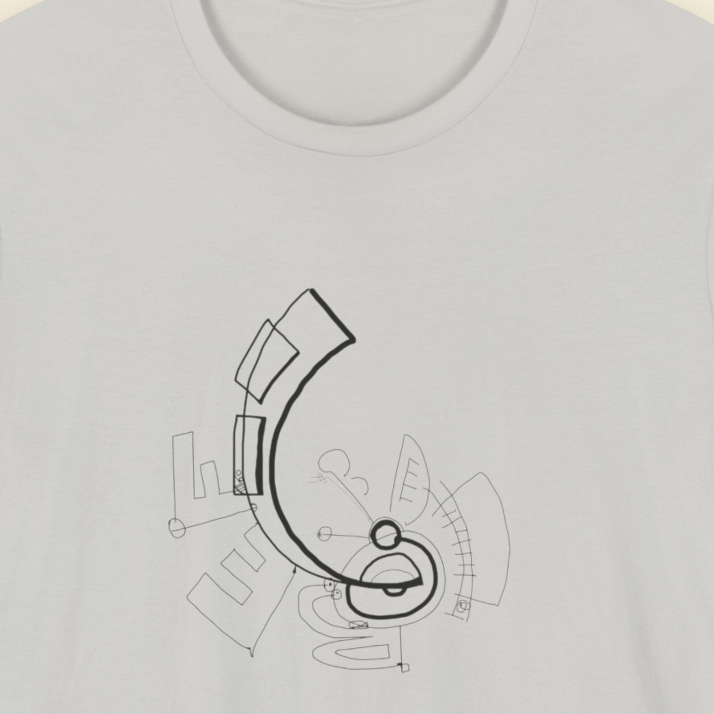 Grey t-shirt with an abstract line drawing on a beige background.