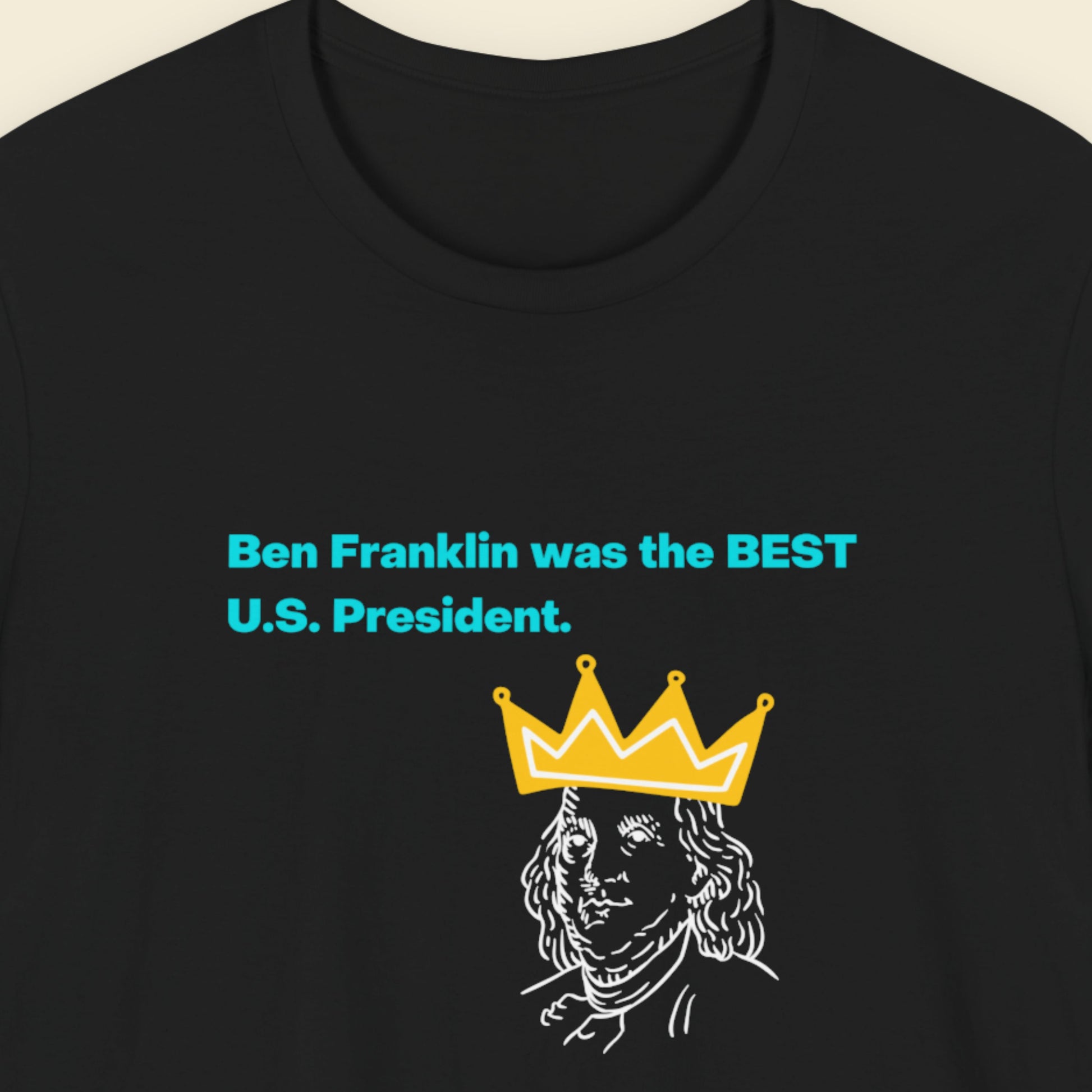 Black t-shirt with humorous colorful text on a beige background.