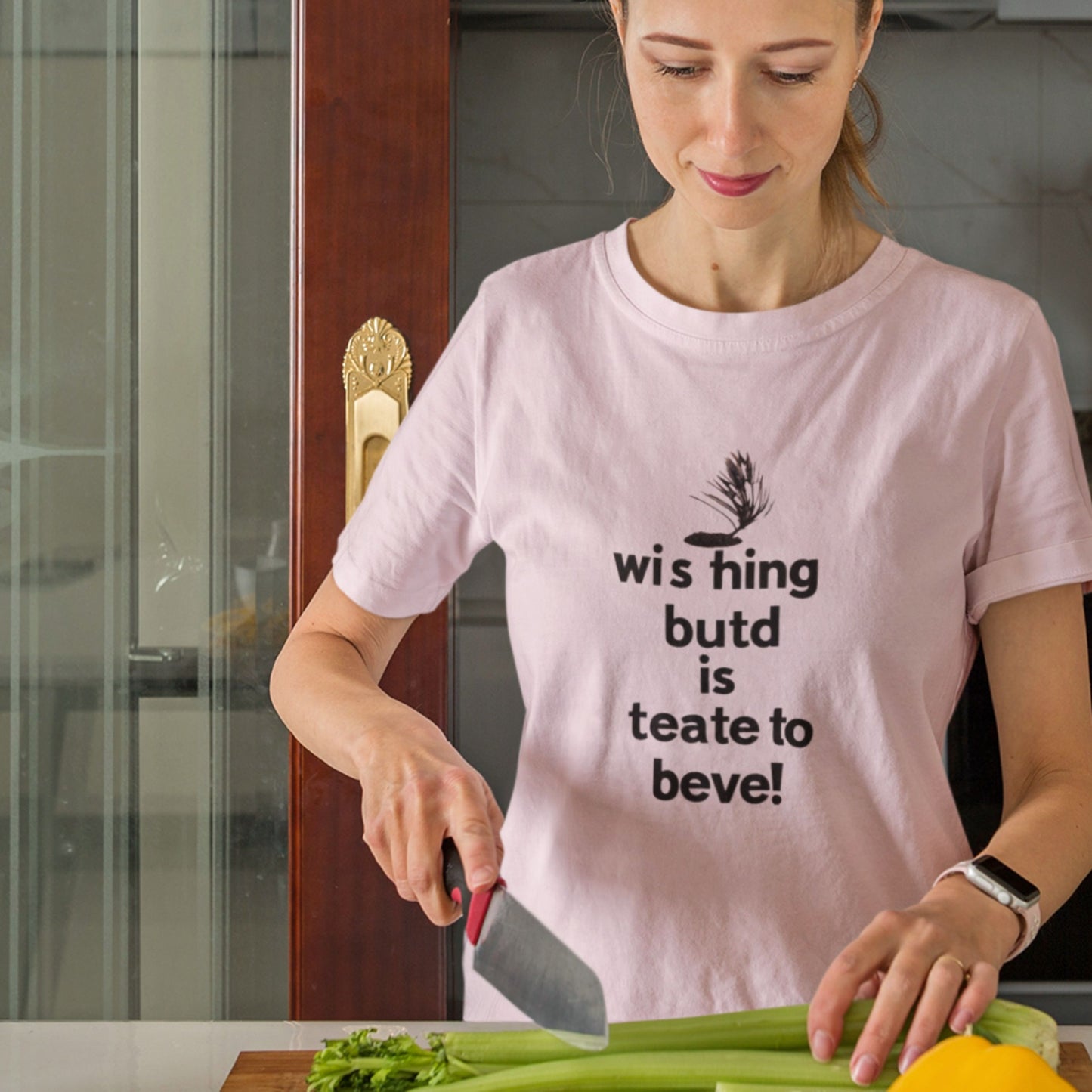 Woman wearing a pink t-shirt with humorous text preparing dinner.