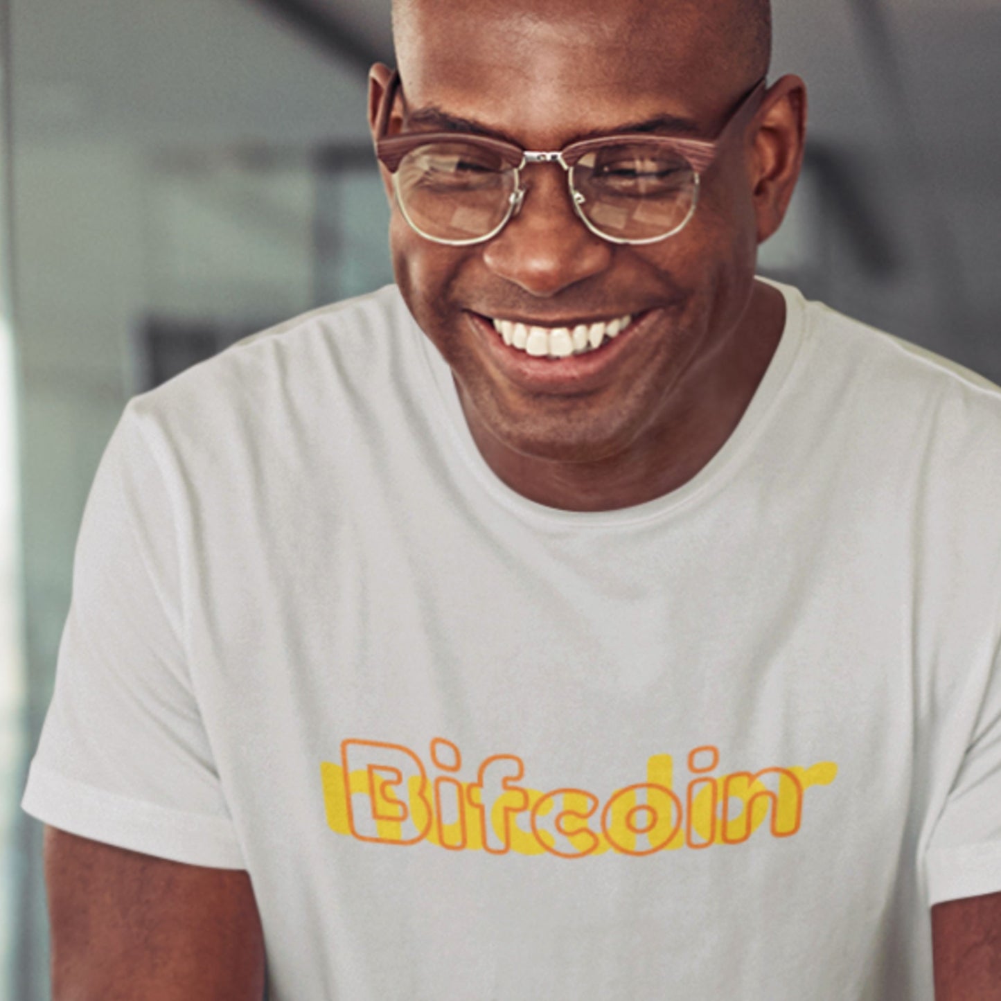 Man wearing a white t-shirt with 'Bifcoin' printed in yellow.