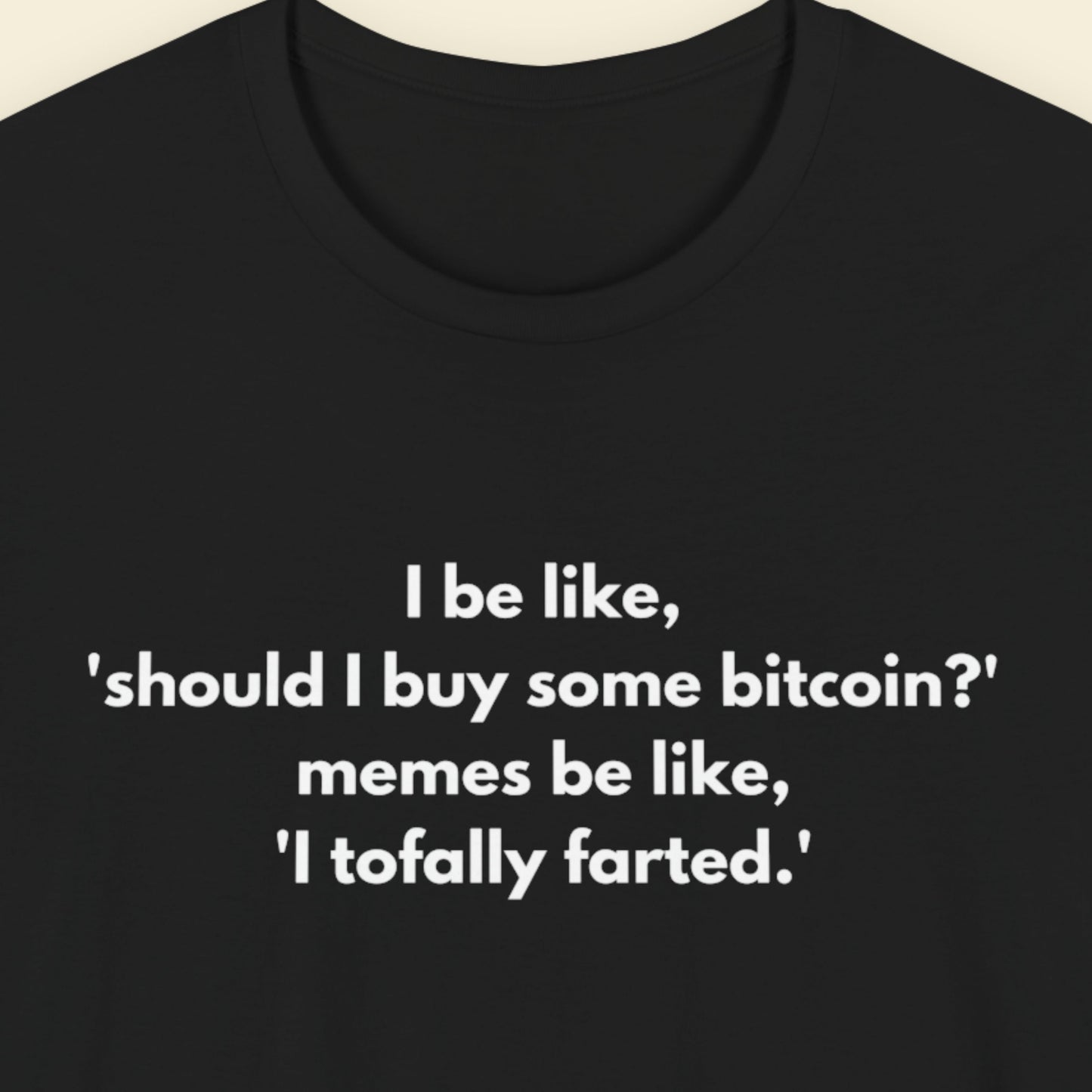 Black t-shirt with humorous text on a beige background.