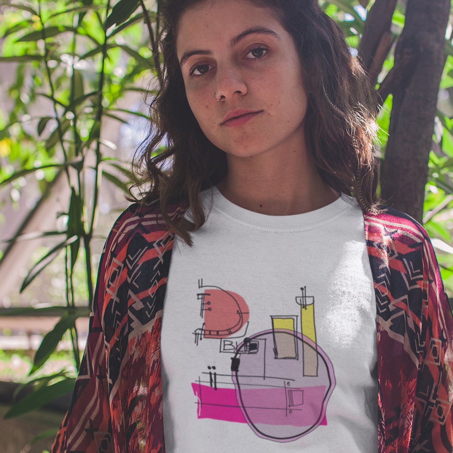 Woman in a zoo wearing a white t-shirt with a colorful abstract drawing.