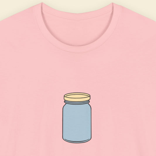 Pink t-shirt with a simple drawing of a blue jar with a beige lid on a beige background.