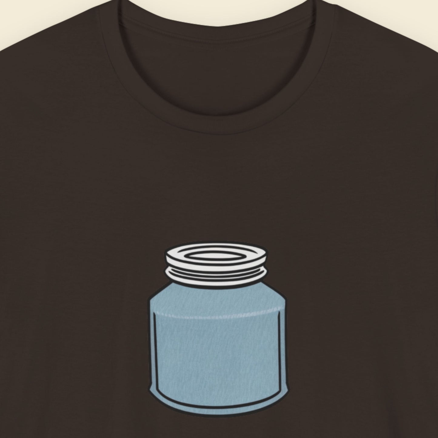 Brown shirt with a drawing of a blue jar with a screw top lid on a beige background.