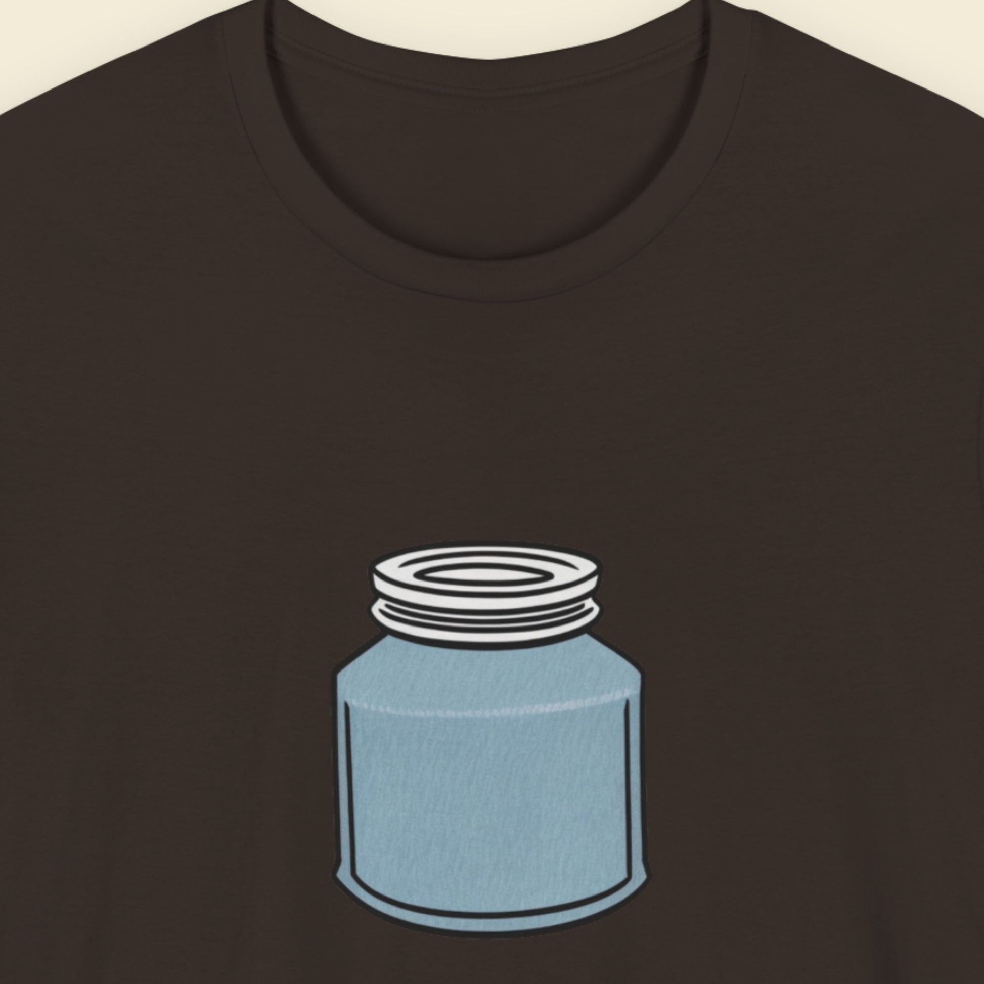 Brown shirt with a drawing of a blue jar with a screw top lid on a beige background.