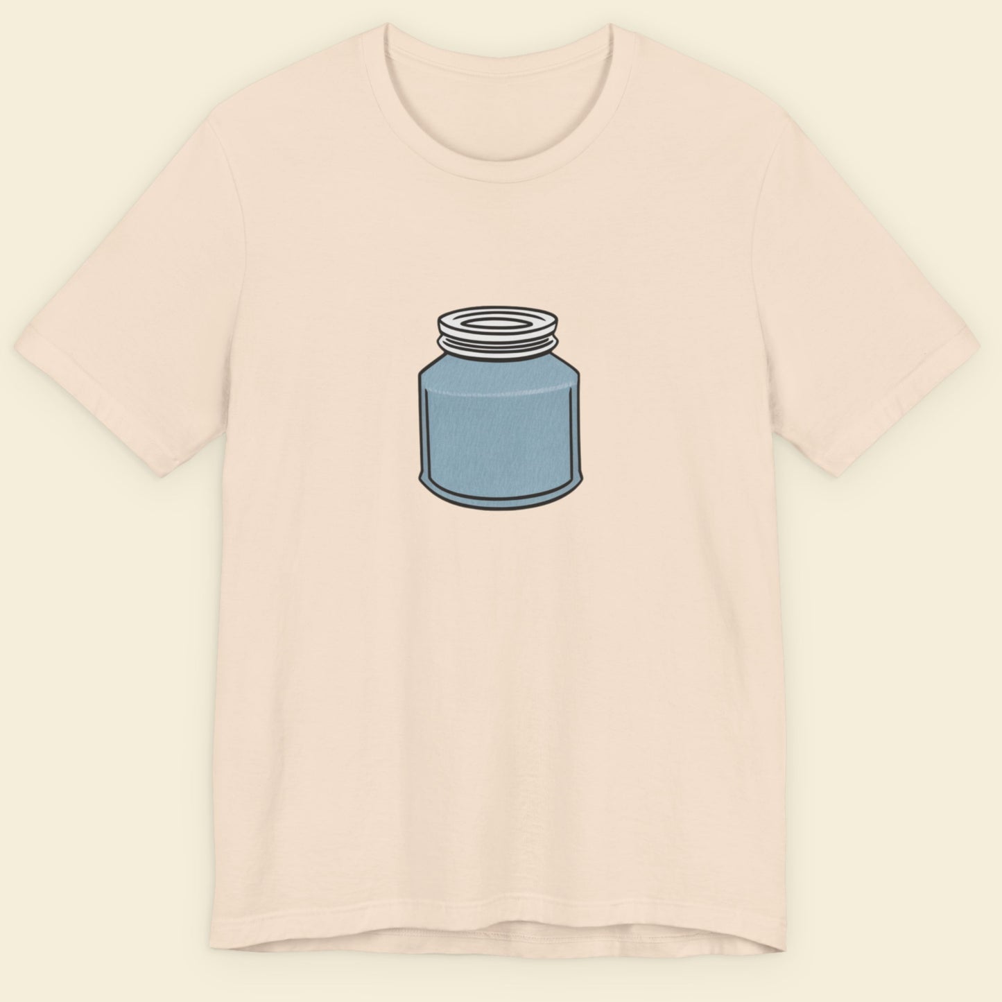 Beige shirt with a drawing of a blue jar with a screw top lid on a beige background.