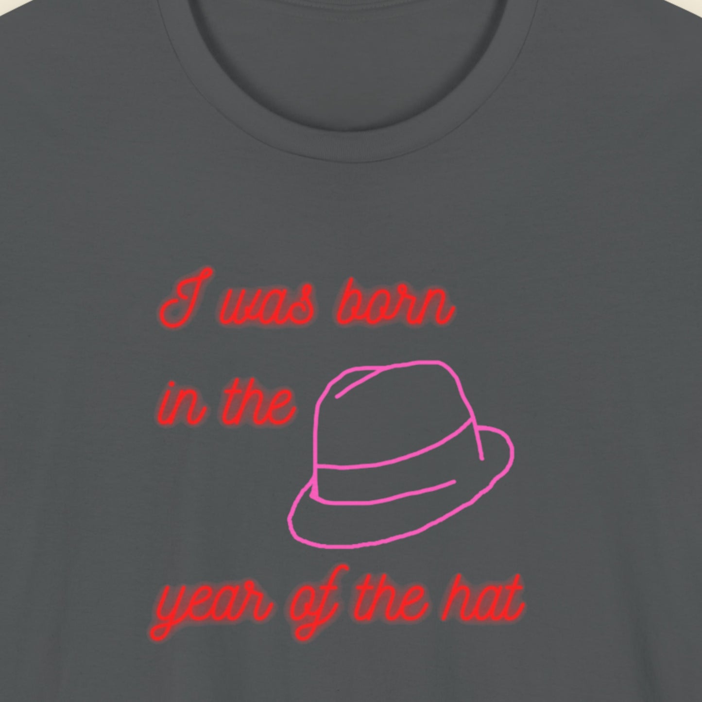 Dark gray t-shirt with red and pink text and a hat graphic.