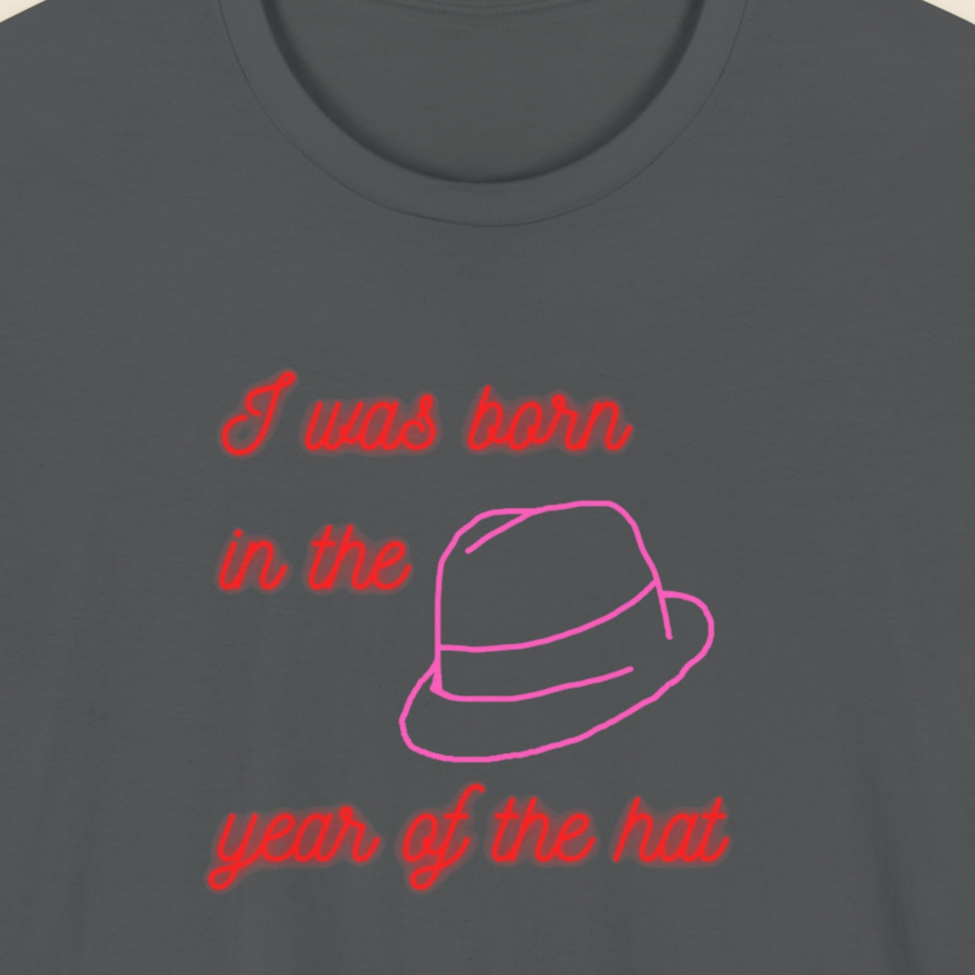 Dark gray t-shirt with red and pink text and a hat graphic.
