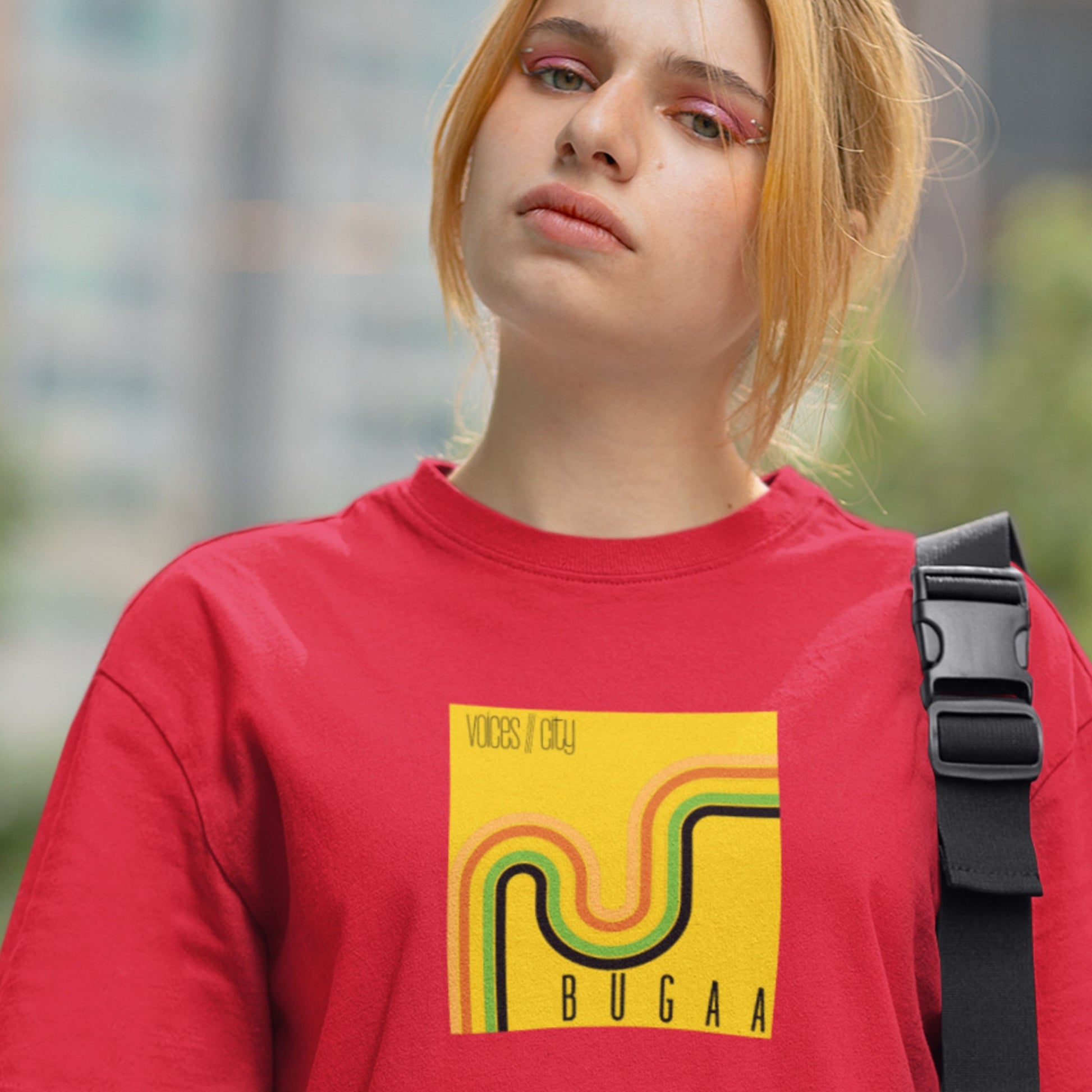 Person wearing a red sweatshirt with a yellow graphic design outdoors