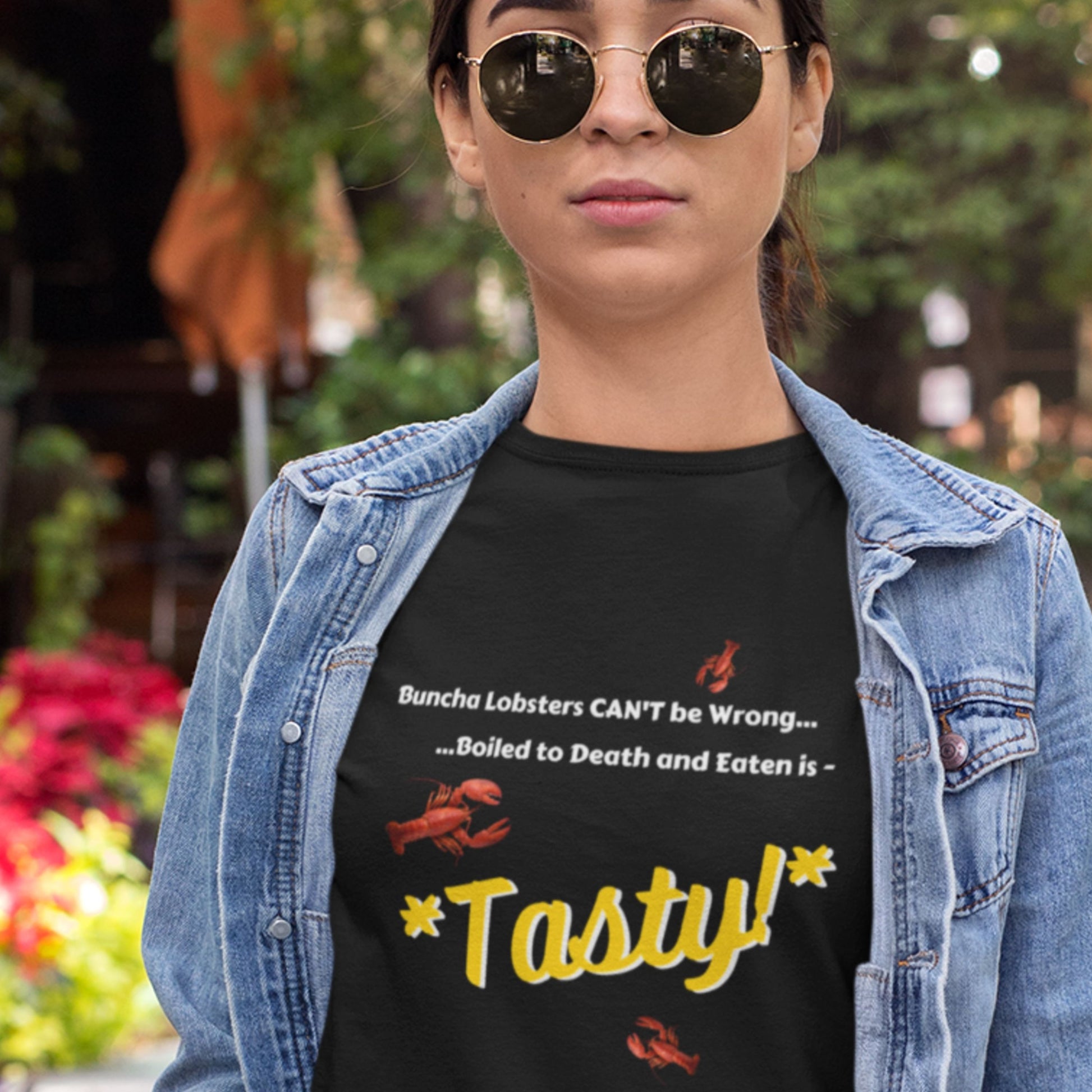 Person wearing a black t-shirt with a humorous lobster-themed message, outdoors.