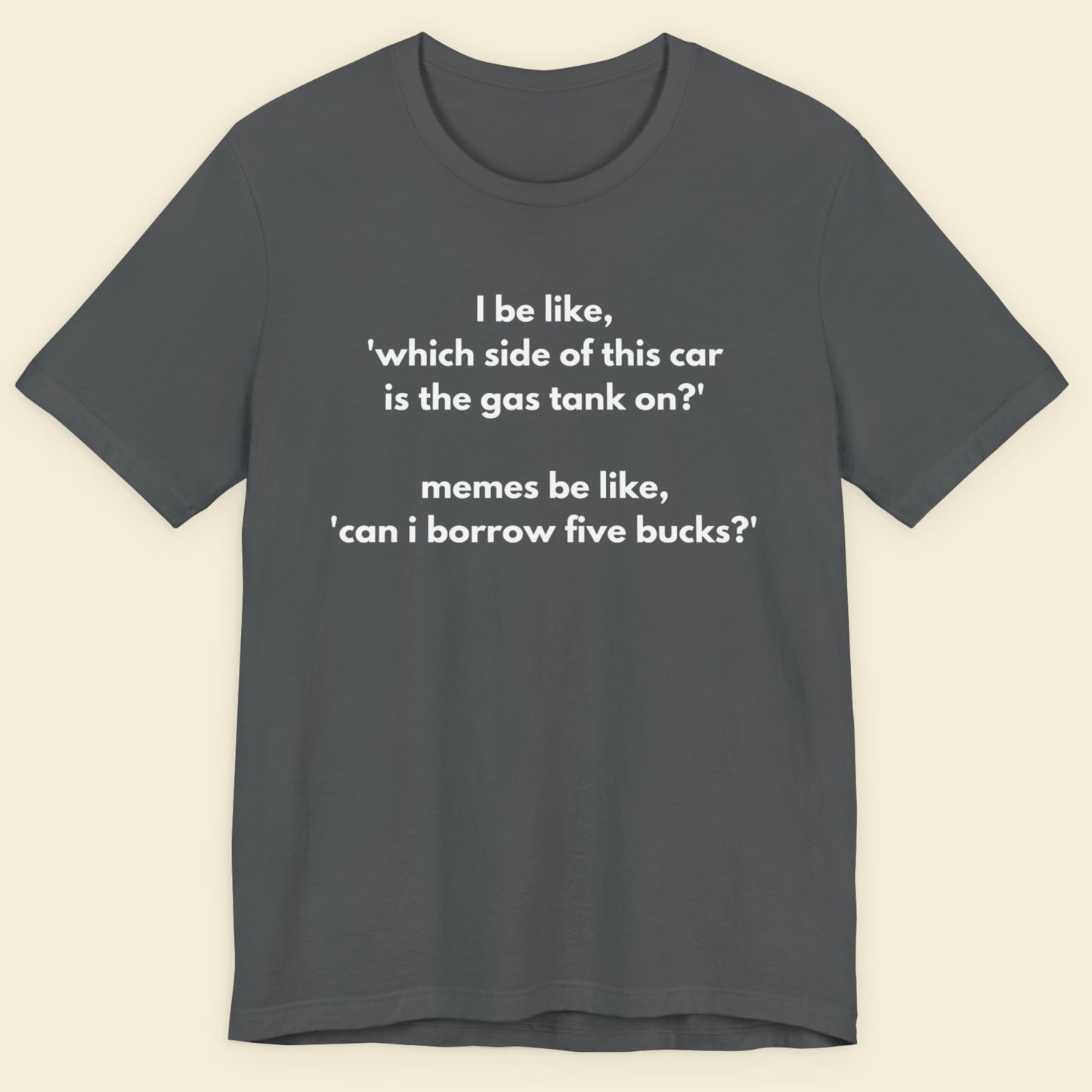 Gray t-shirt with humorous text on a beige background.