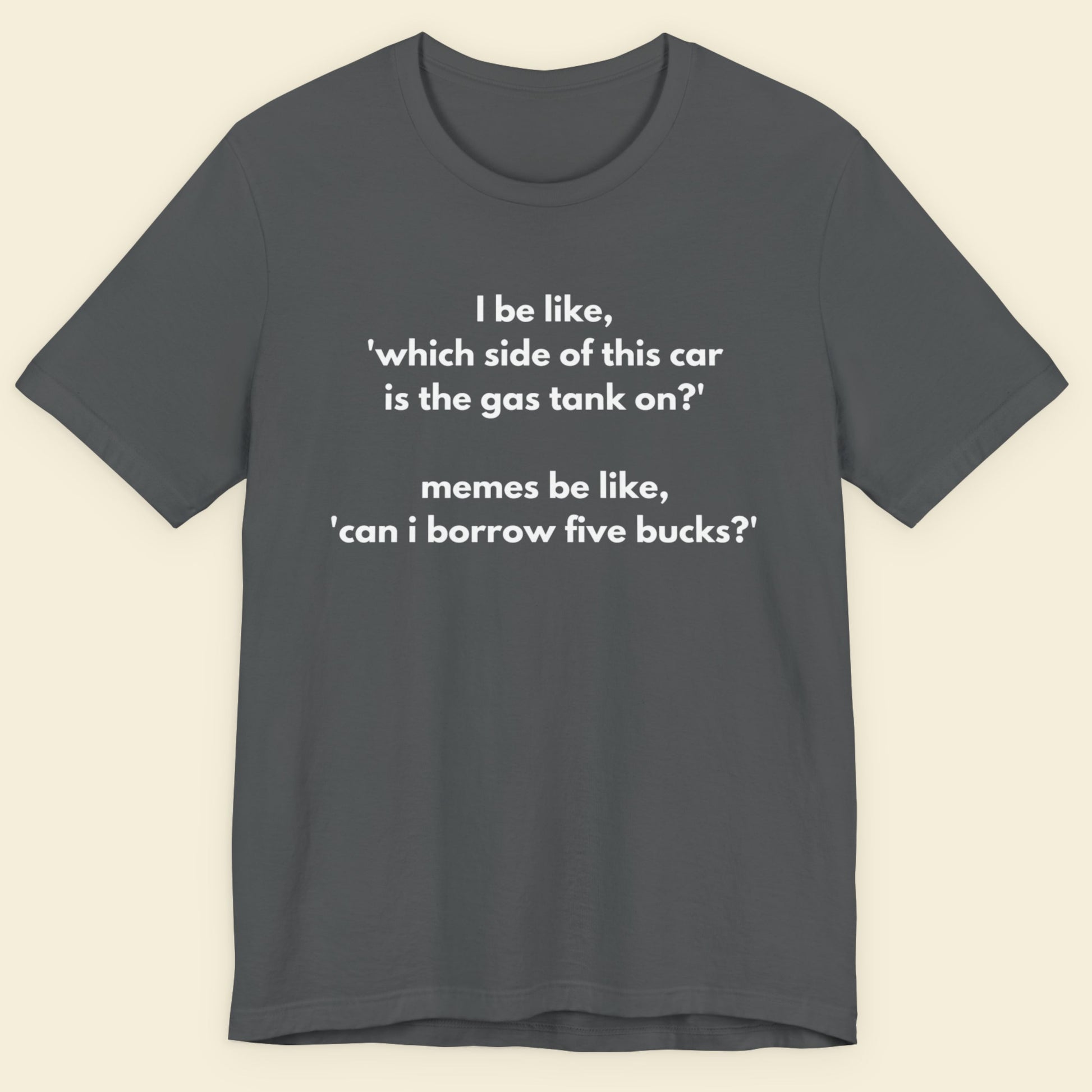 Gray t-shirt with humorous text on a beige background.