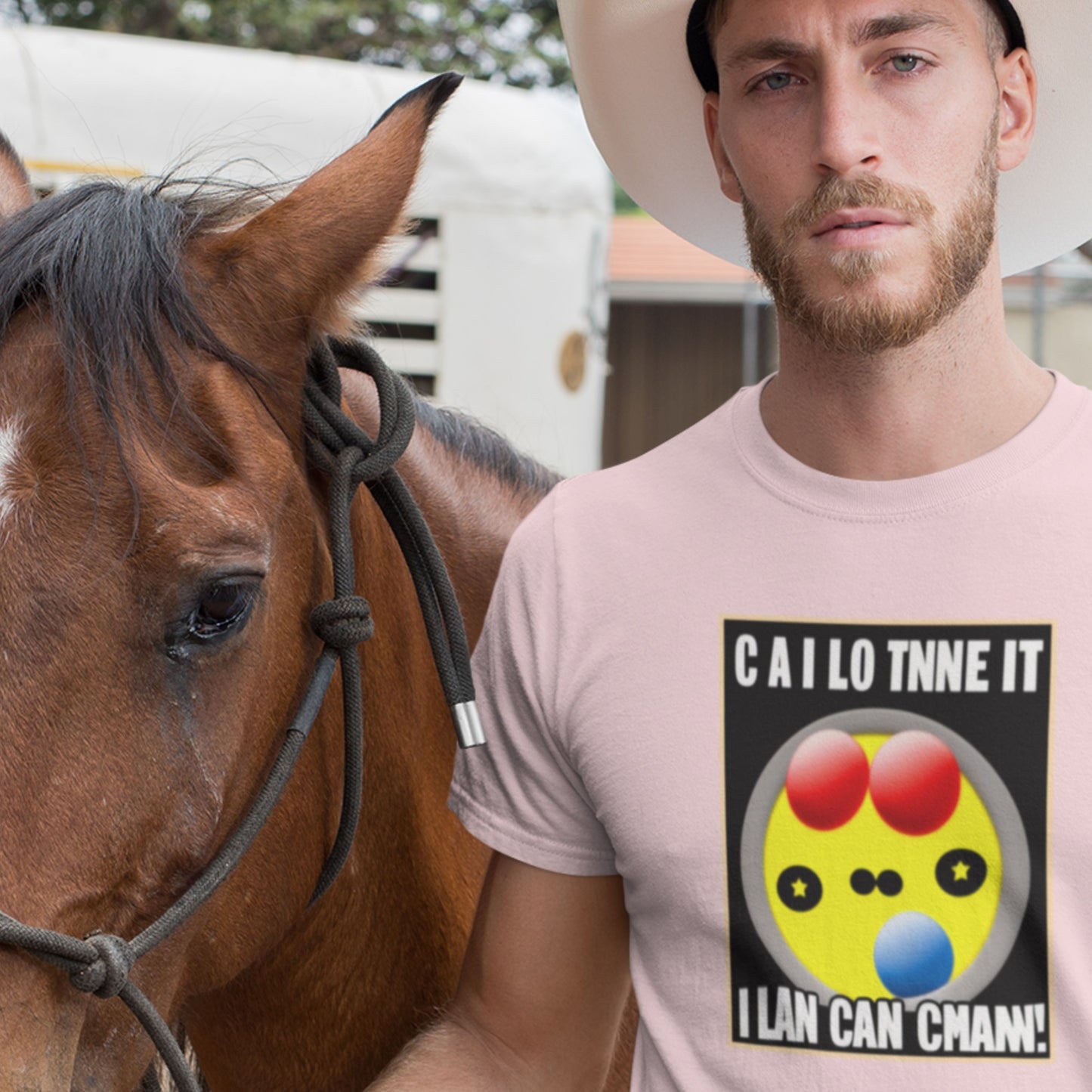 Man wearing a pink t-shirt with a colorful design and text, standing next to a horse.