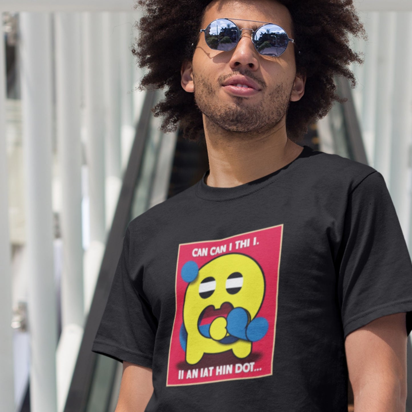 Man wearing a black t-shirt with a colorful graphic design outdoors.