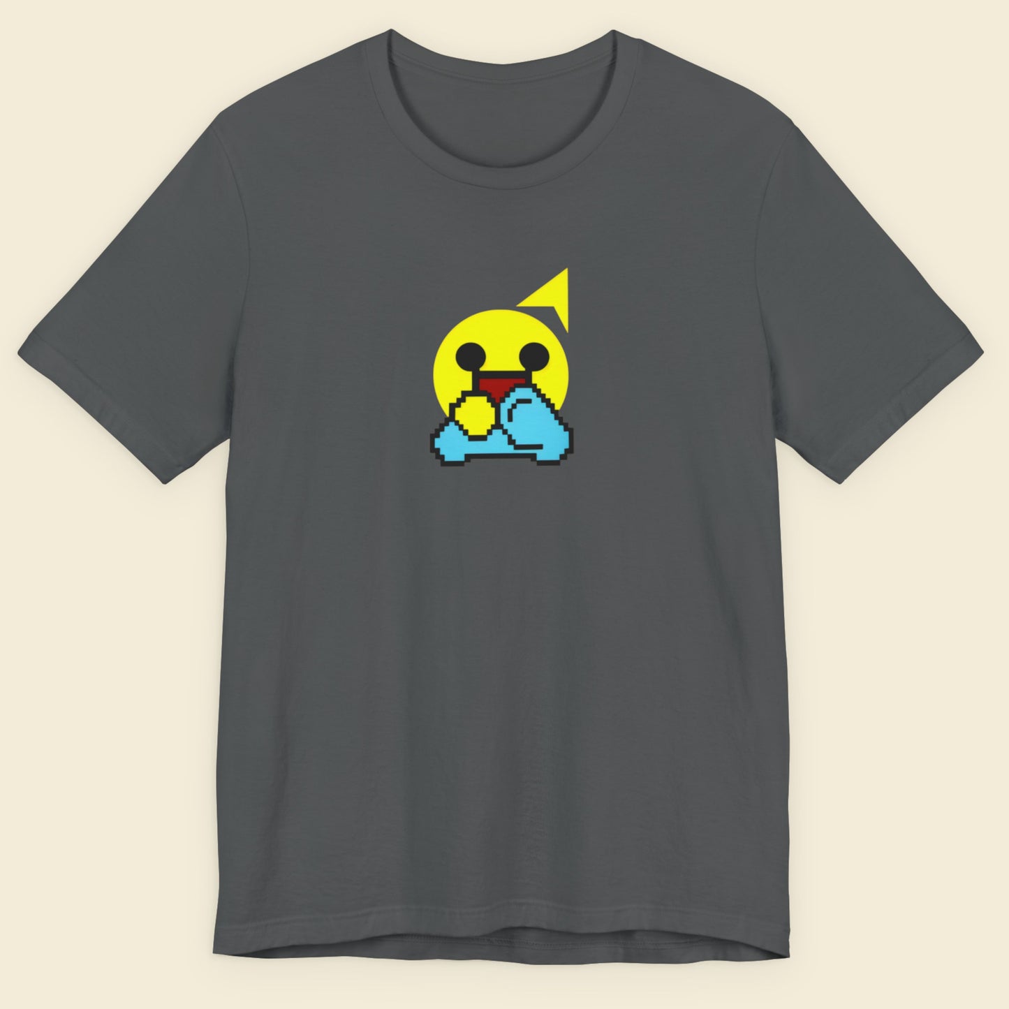 Gray t-shirt with a pixelated emoji design on a beige background.