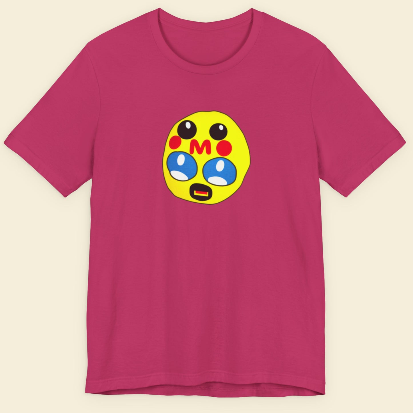 Pink t-shirt with a colorful emoji design on a beige background.