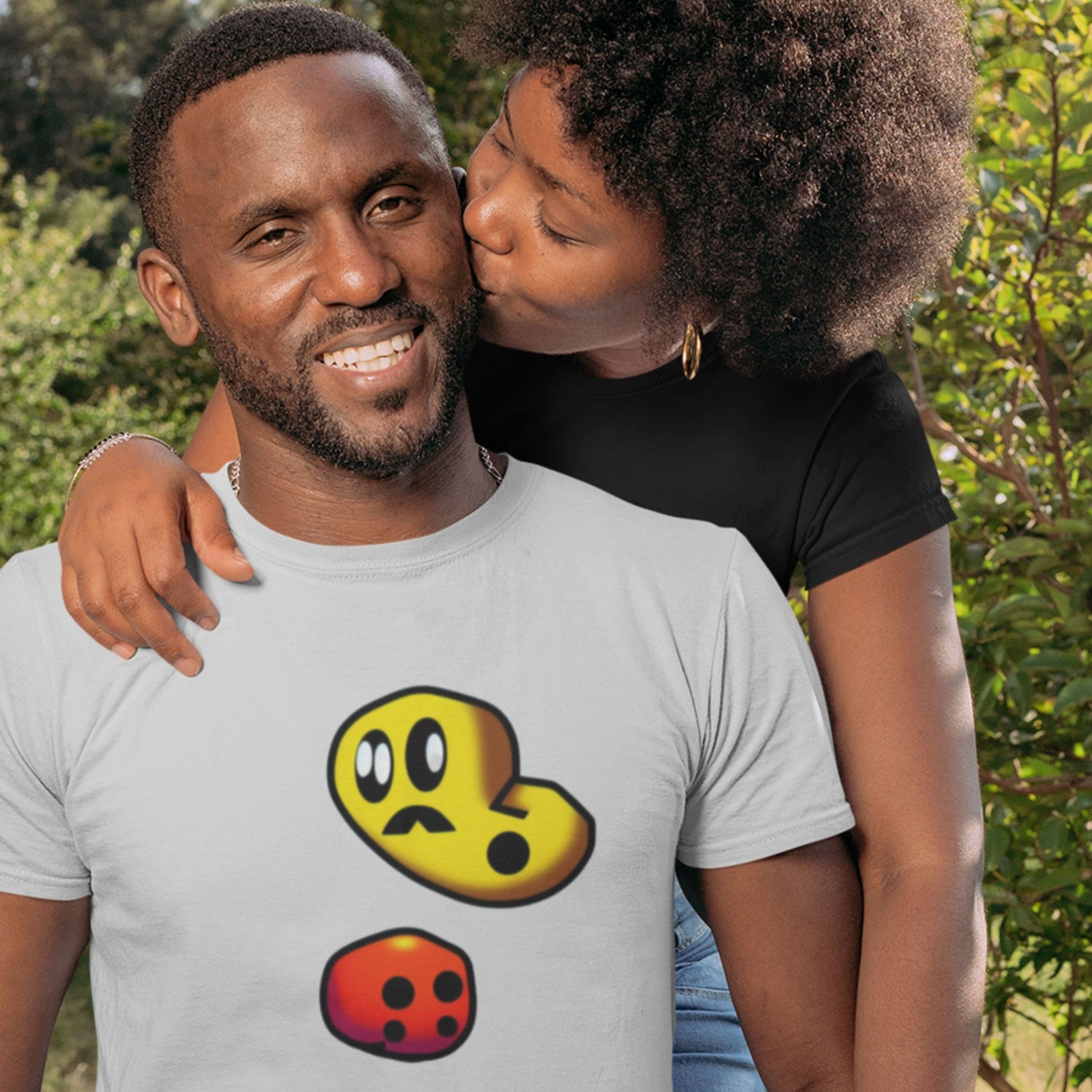 Man wearing a t-shirt with cartoon character designs, standing outdoors with a woman.
