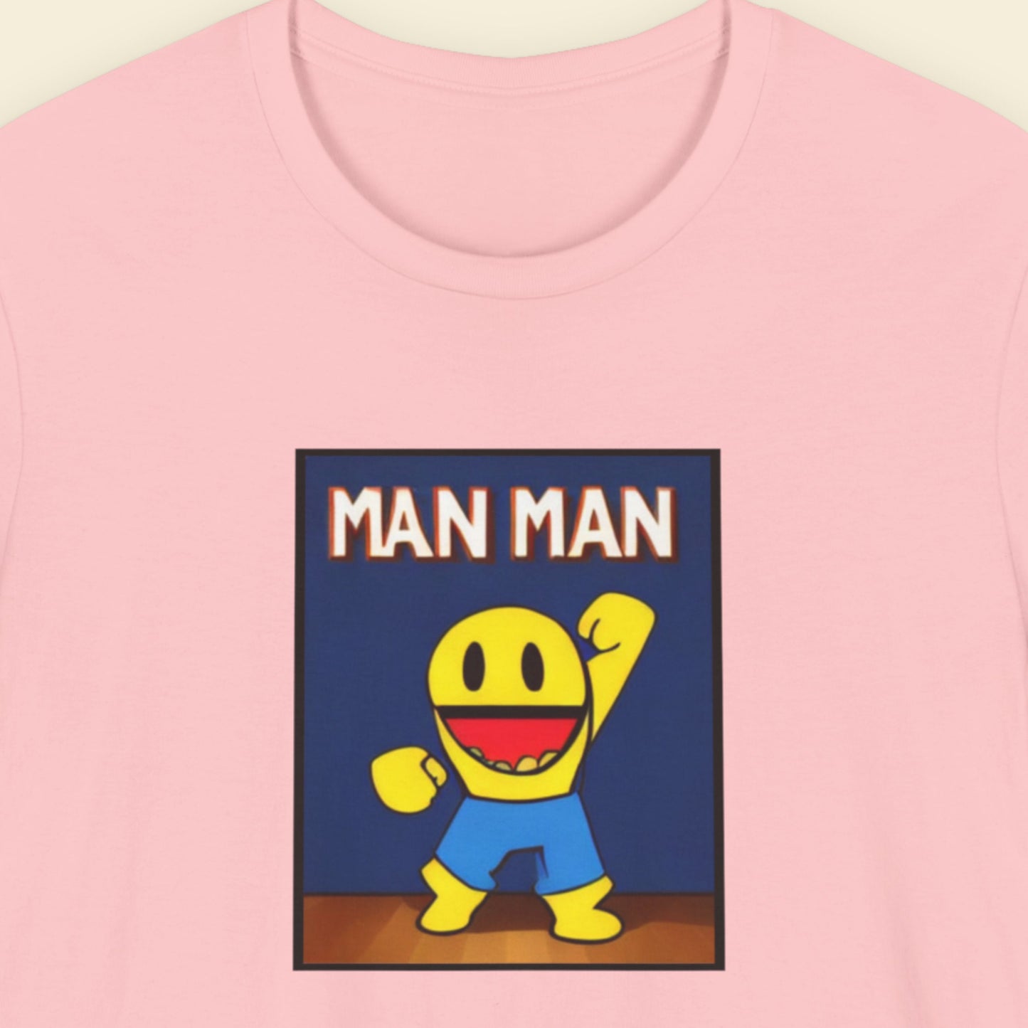 Pink t-shirt with a cartoon character and 'MAN MAN' text on a blue background.