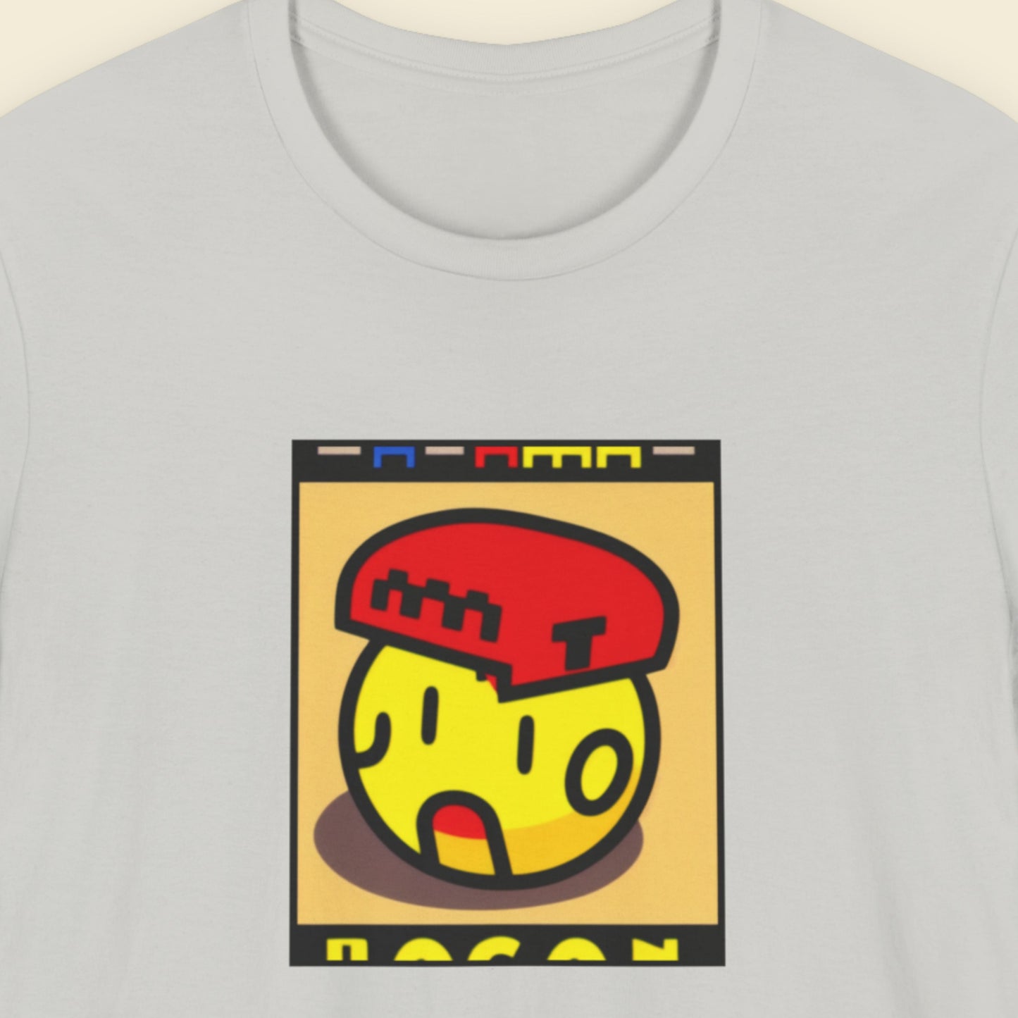 Gray t-shirt with a colorful graphic design on a beige background.