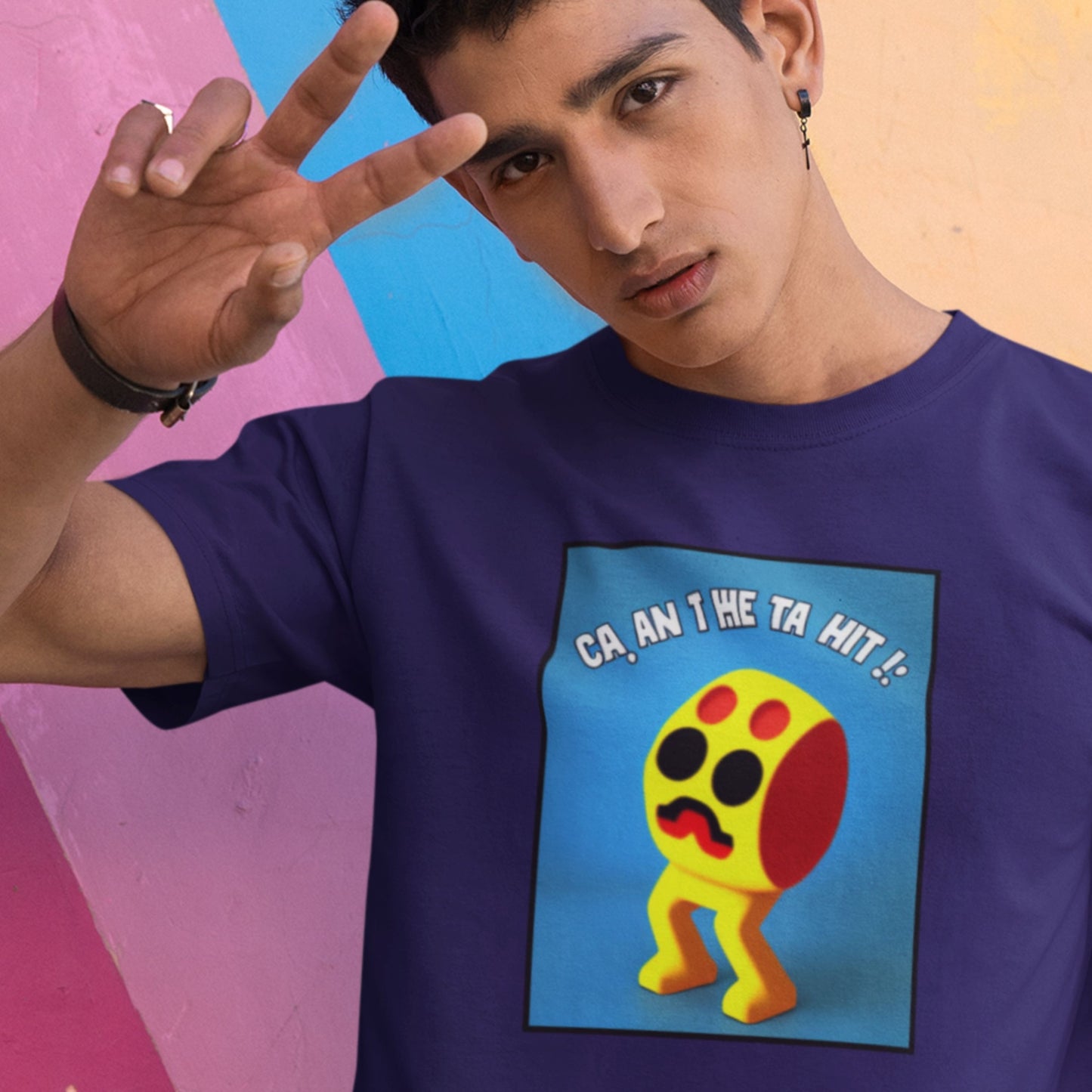Person wearing a blue t-shirt with a colorful graphic design on a multicolored background.