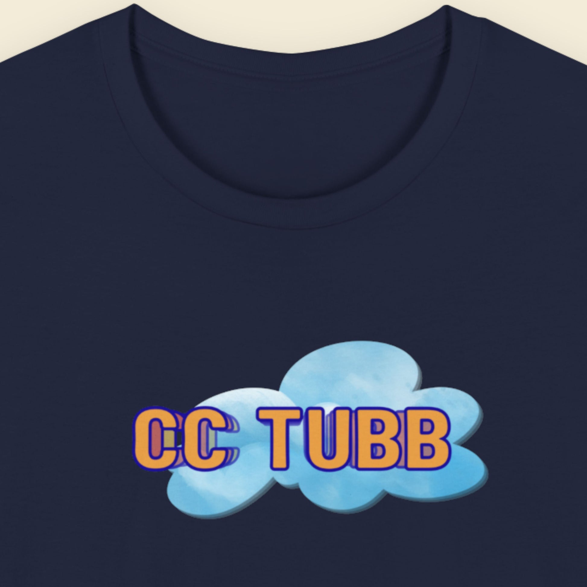 Navy blue t-shirt with 'CC TUBB' text and cloud graphic on a beige background.