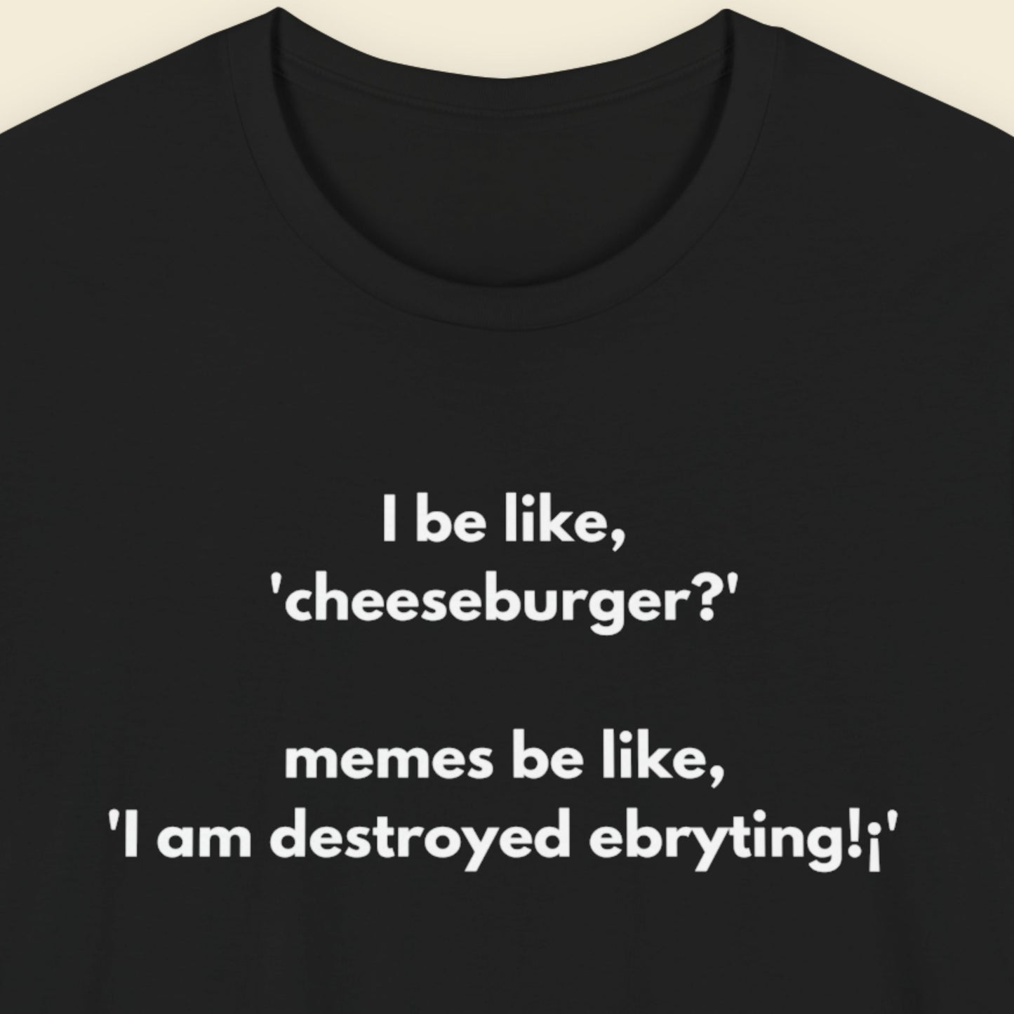 Black t-shirt with humorous text design on a beige background.