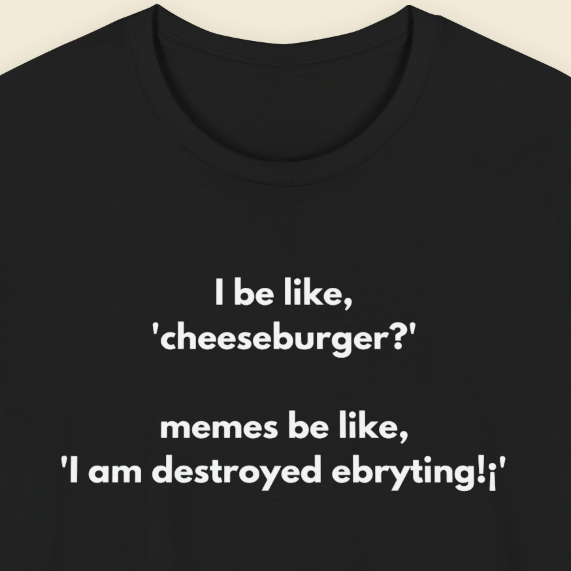 Black t-shirt with humorous text design on a beige background.