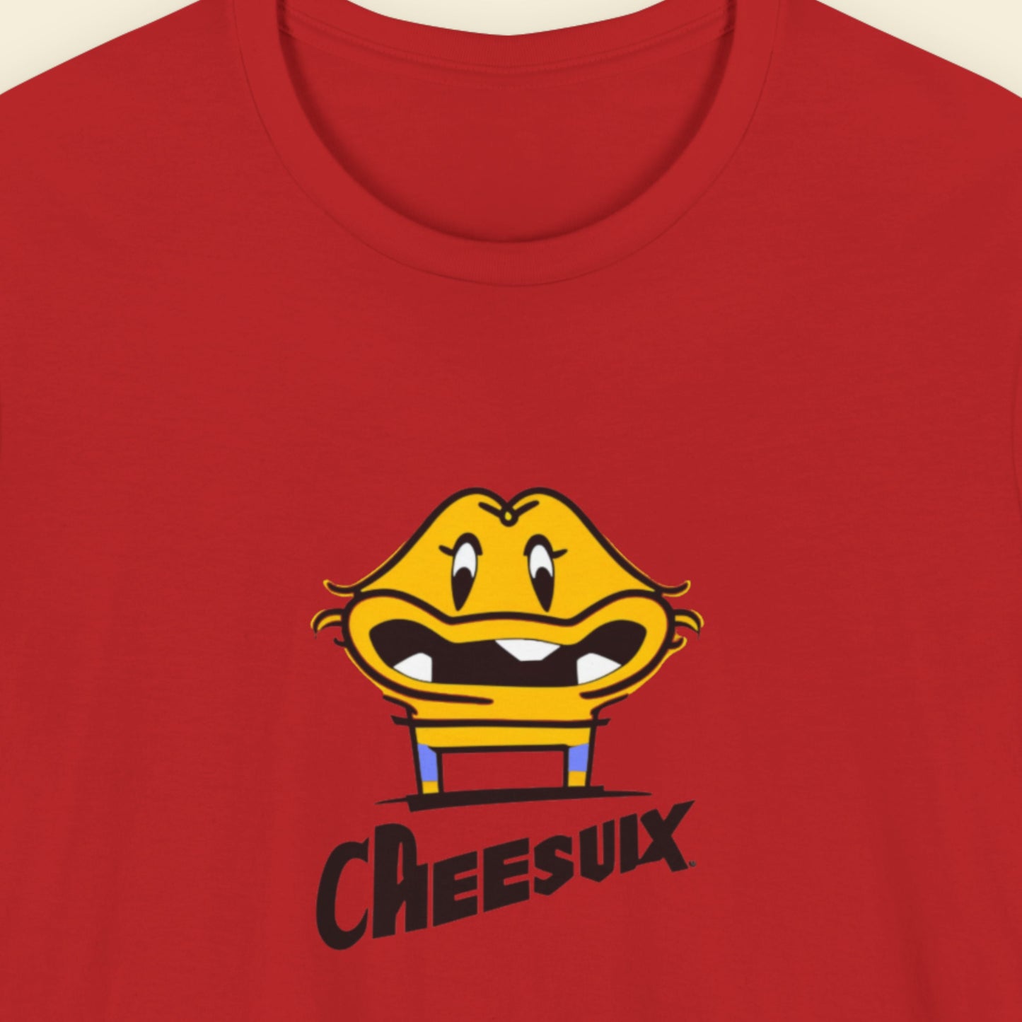 Red t-shirt with a fun, colorful cartoon illustration on a beige background.