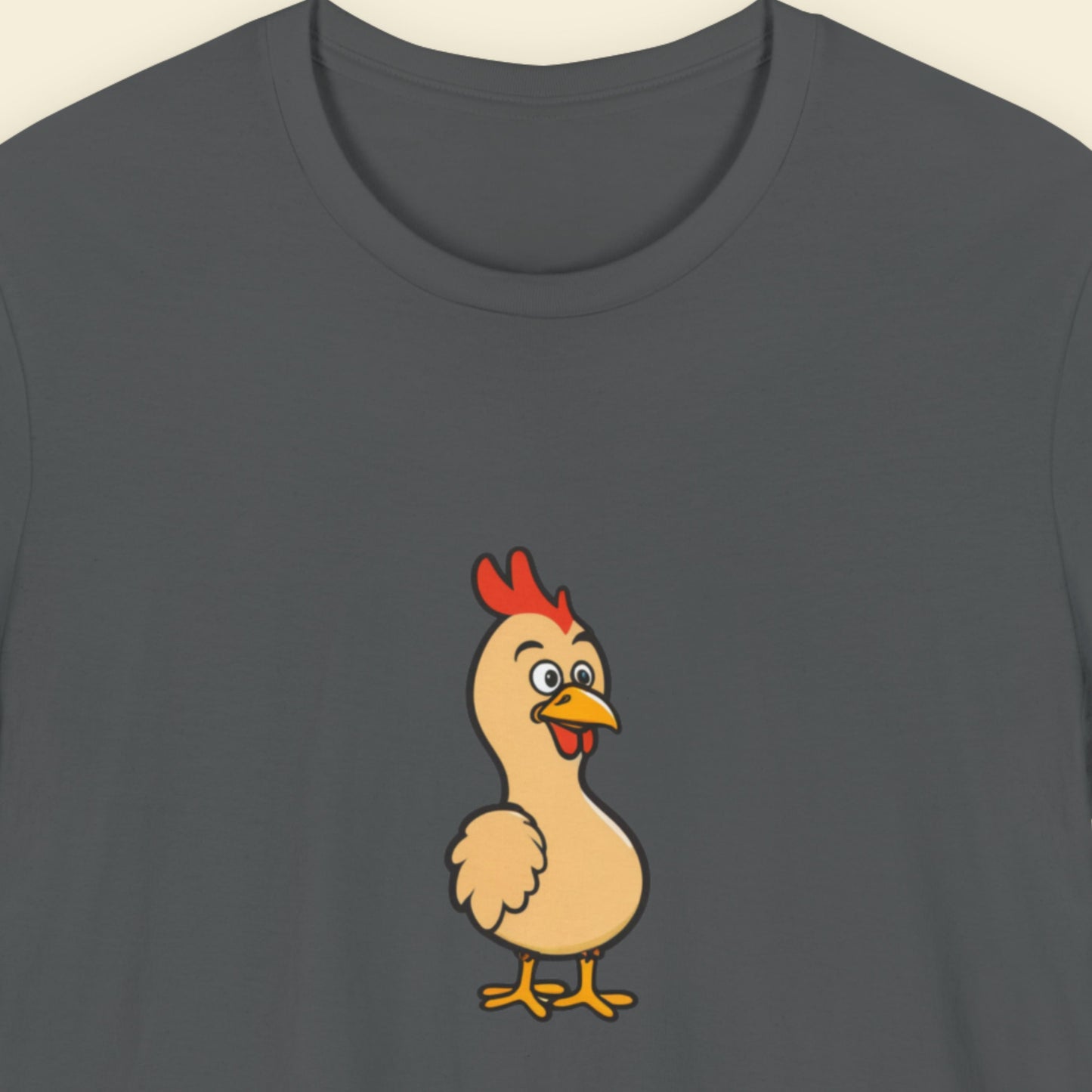 Dark gray t-shirt with a cartoon chicken design on a beige background