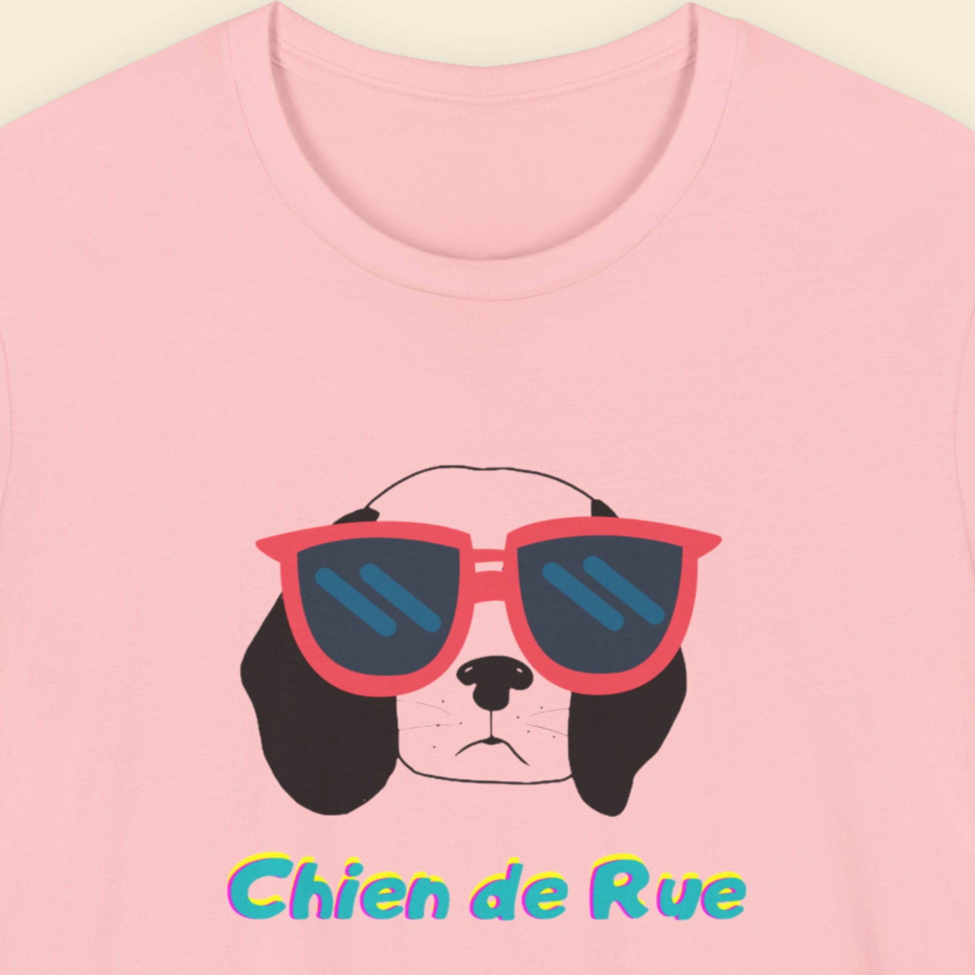 Pink t-shirt with a dog wearing sunglasses and 'Chien de Rue' text on a light pink background.