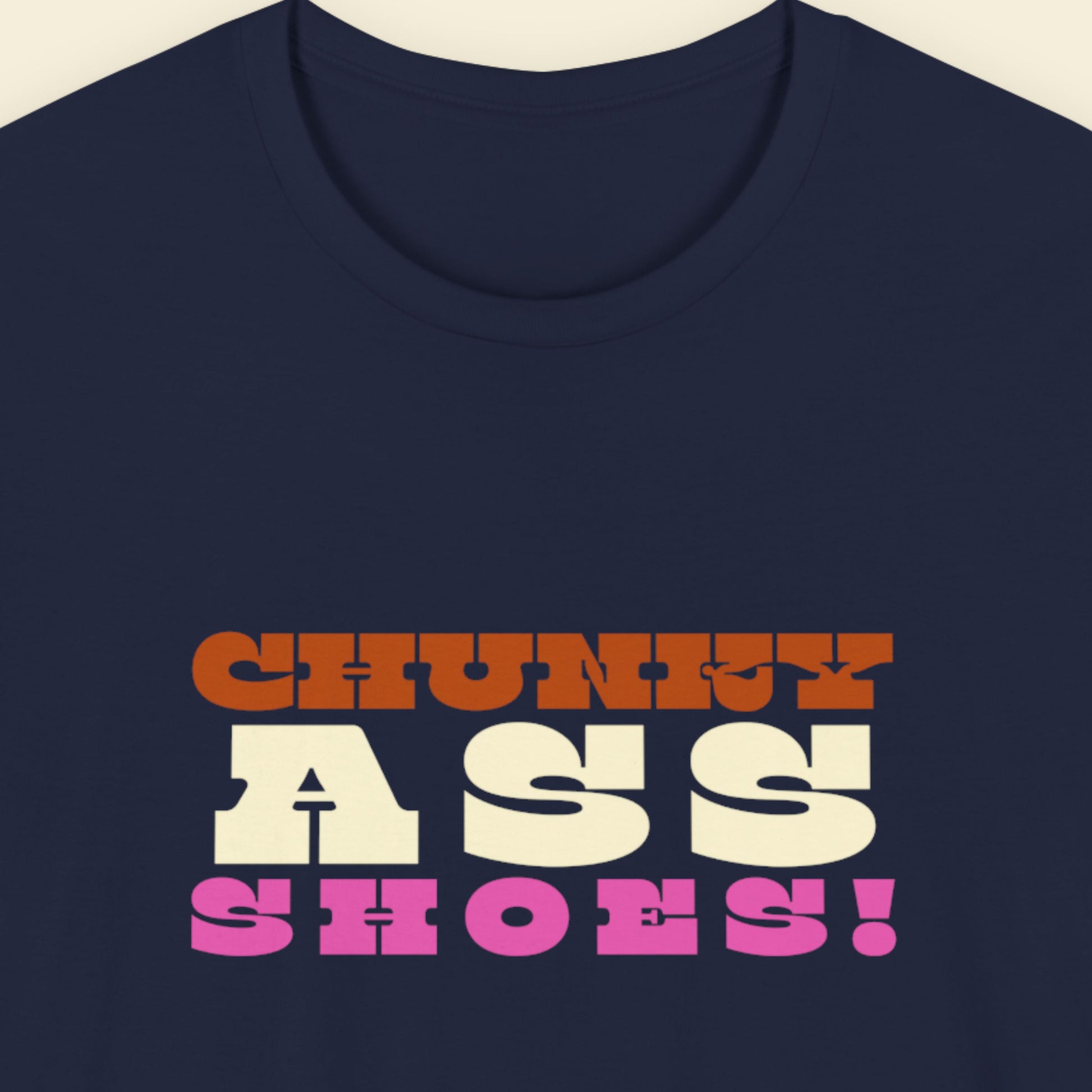 Navy blue t-shirt with colorful text design on a beige background.