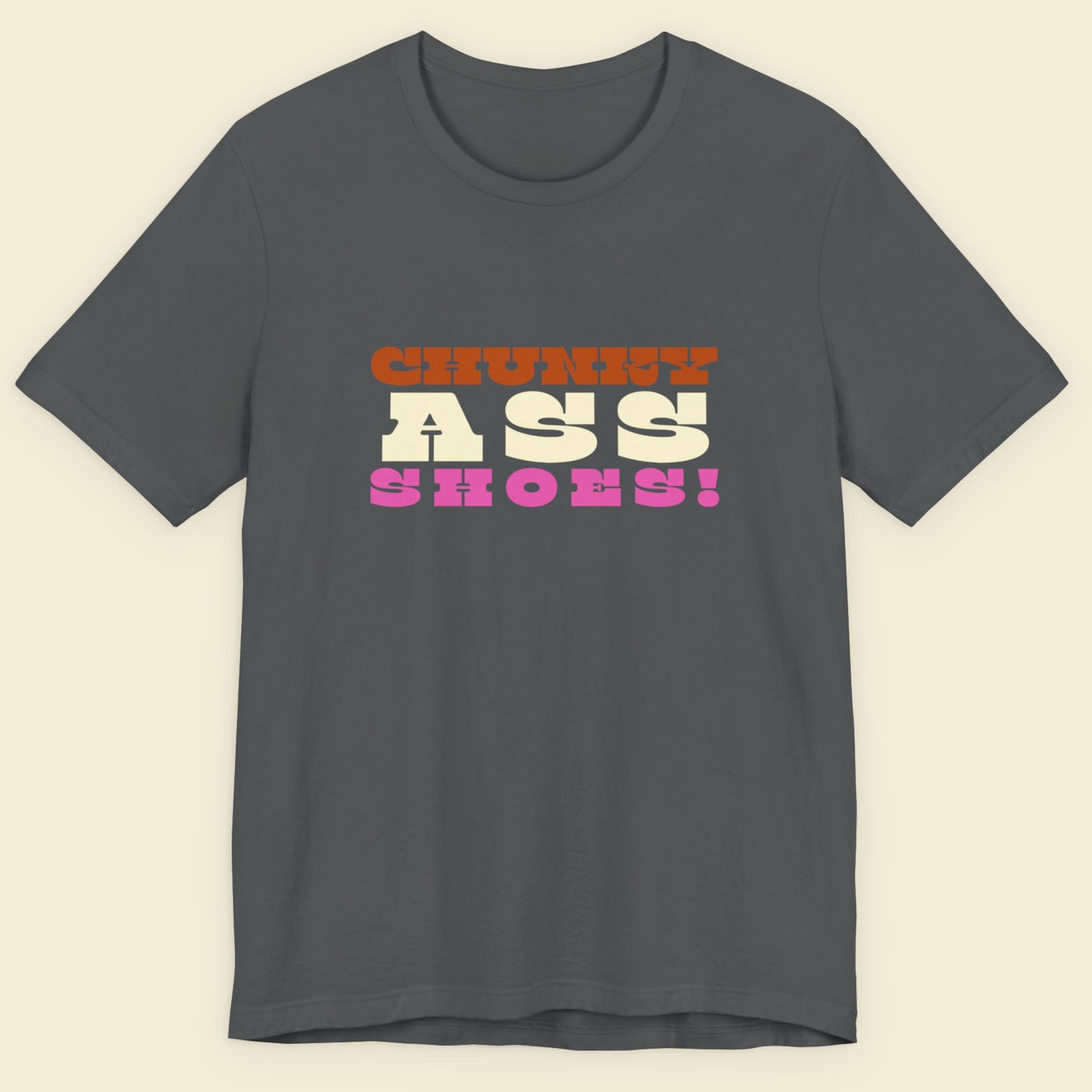 Gray t-shirt with colorful text on a beige background.