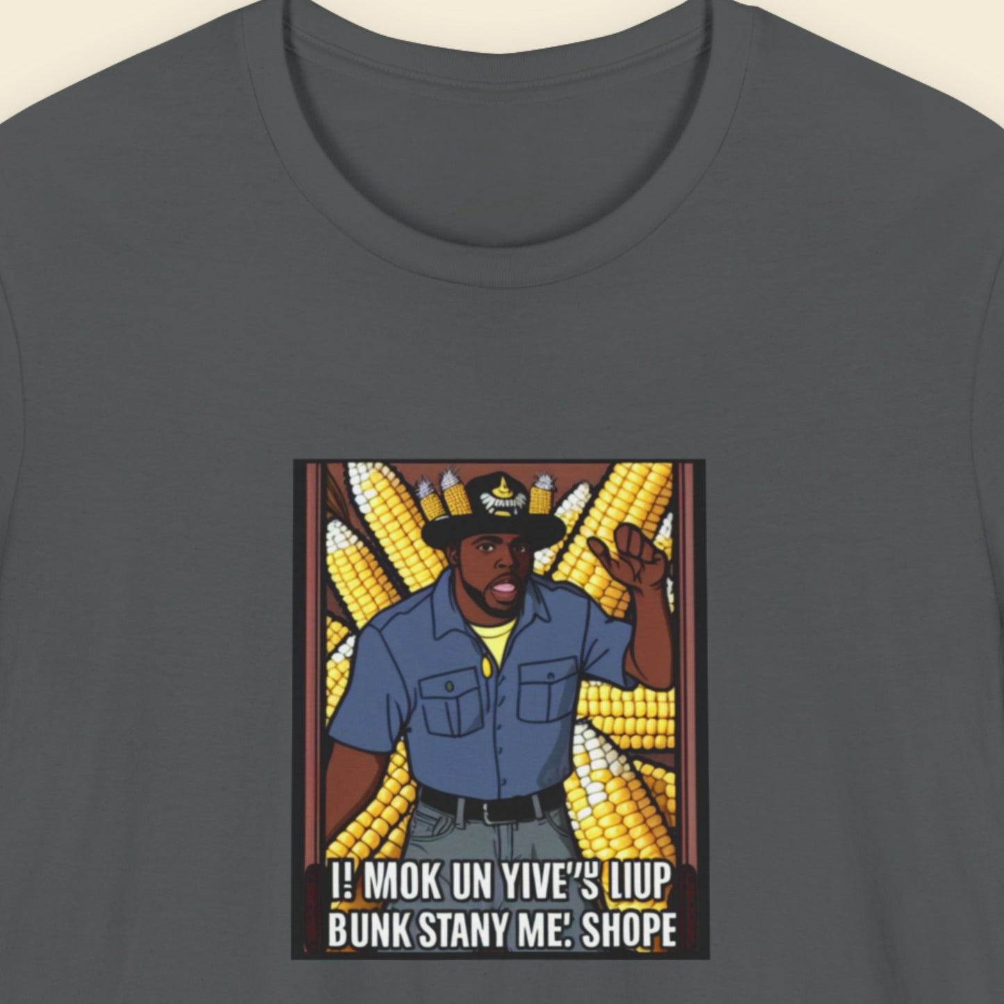 Gray t-shirt with a graphic of a person in a blue shirt and hat surrounded by corn, with text on a beige background.