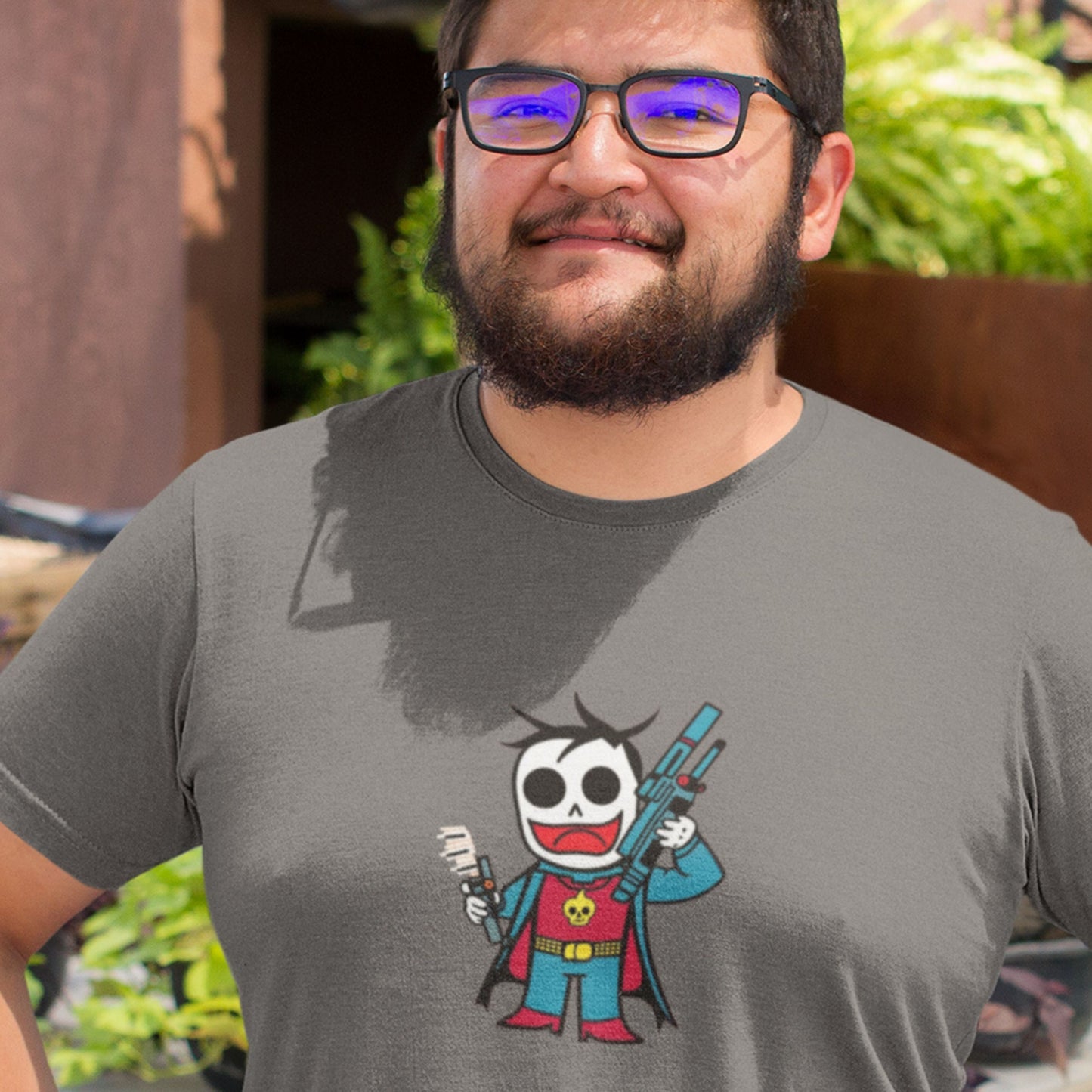 Glasses man wearing a dark grey tee with a fun, colorful cartoon illustration on a beige background.