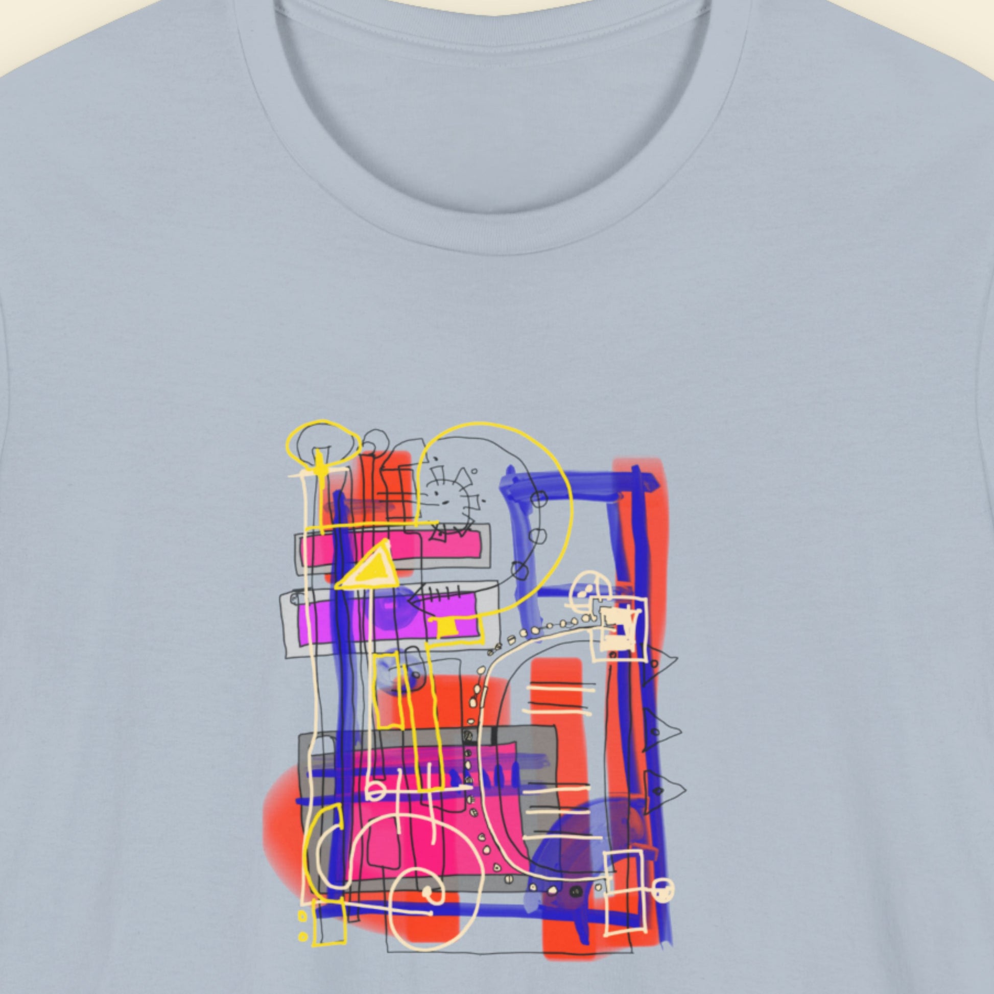 Blue t-shirt with a colorful drawing on a beige background.