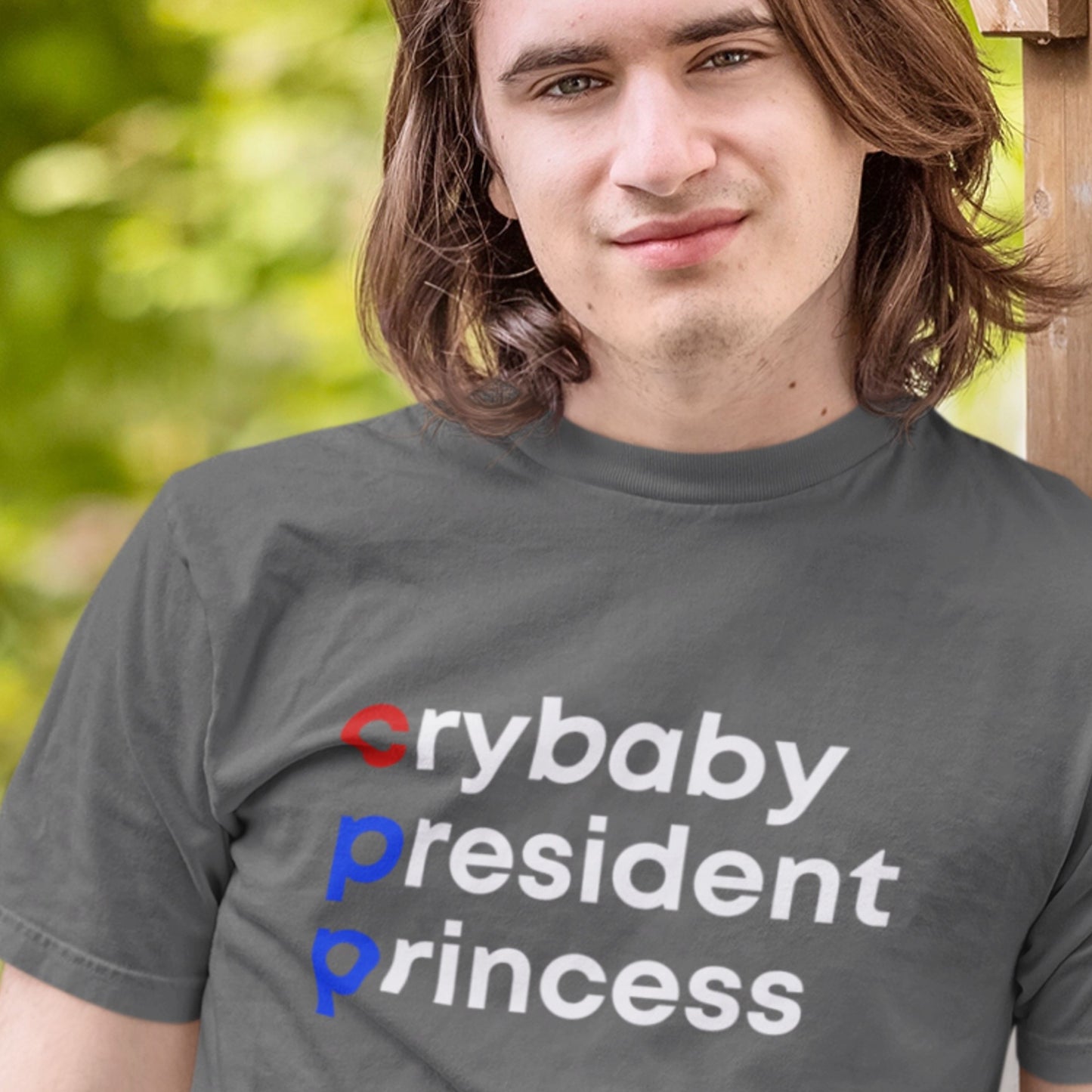 Person wearing a gray t-shirt with colorful text outdoors
