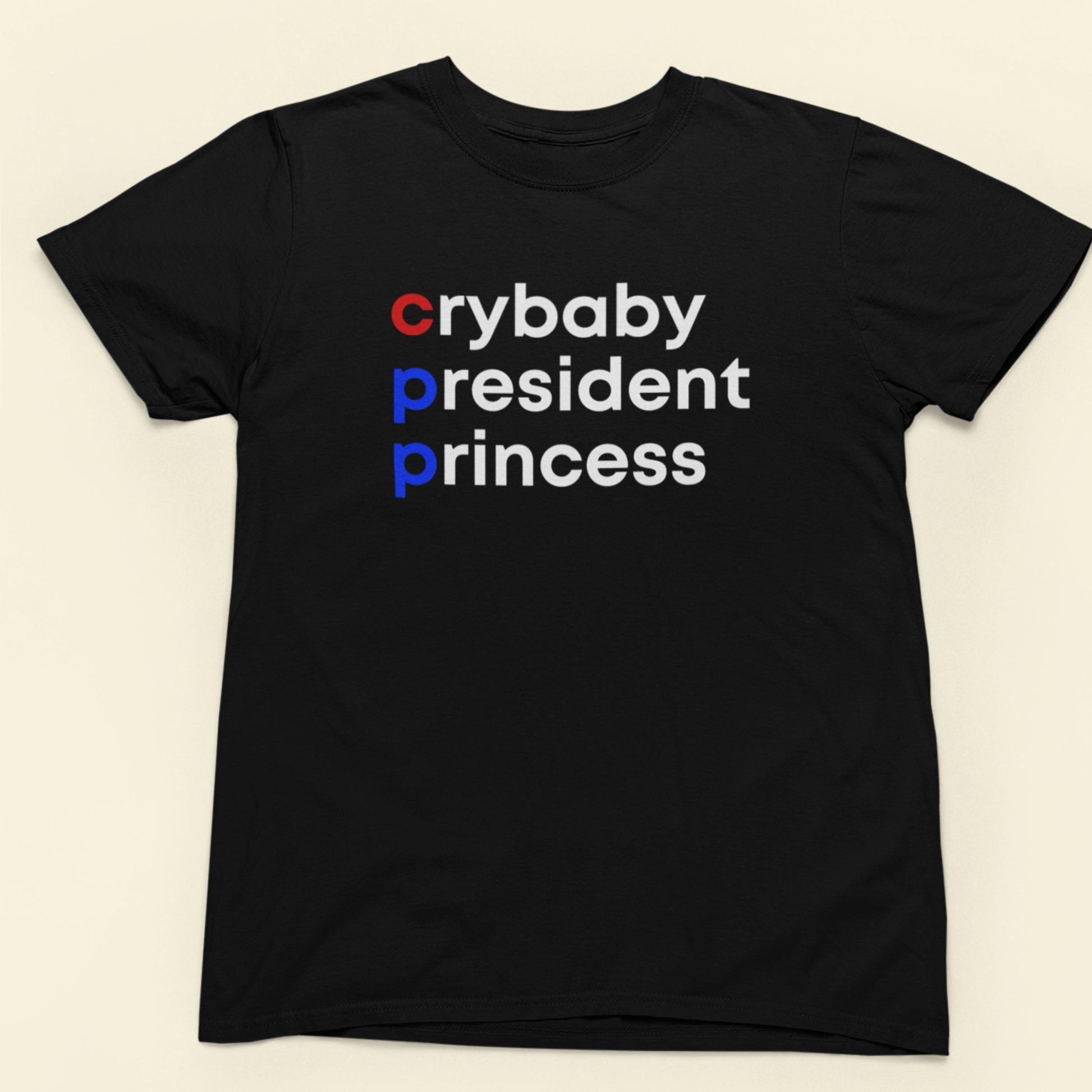 Black t-shirt with 'crybaby president princess' text on a beige background