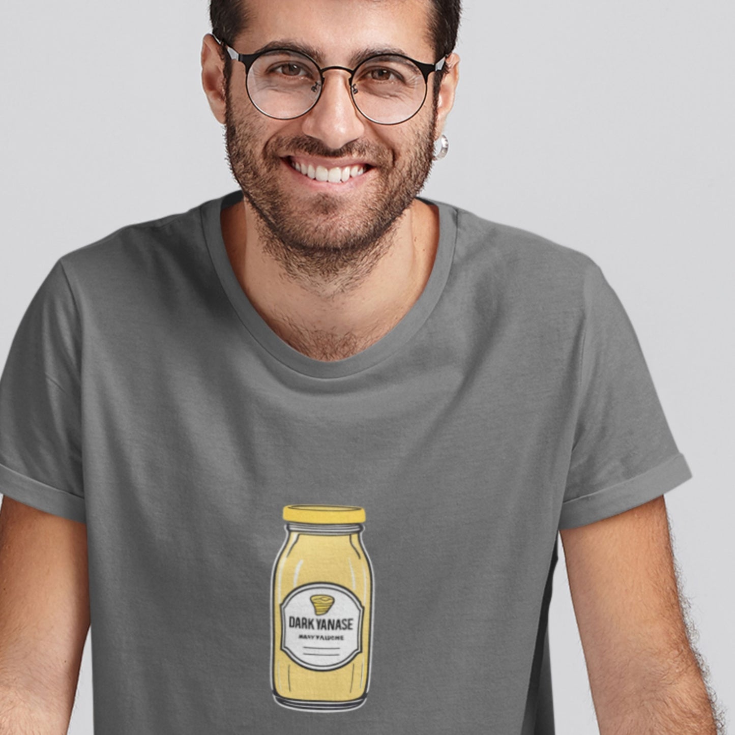 Man wearing a gray t-shirt with a mustard bottle graphic on a plain background.