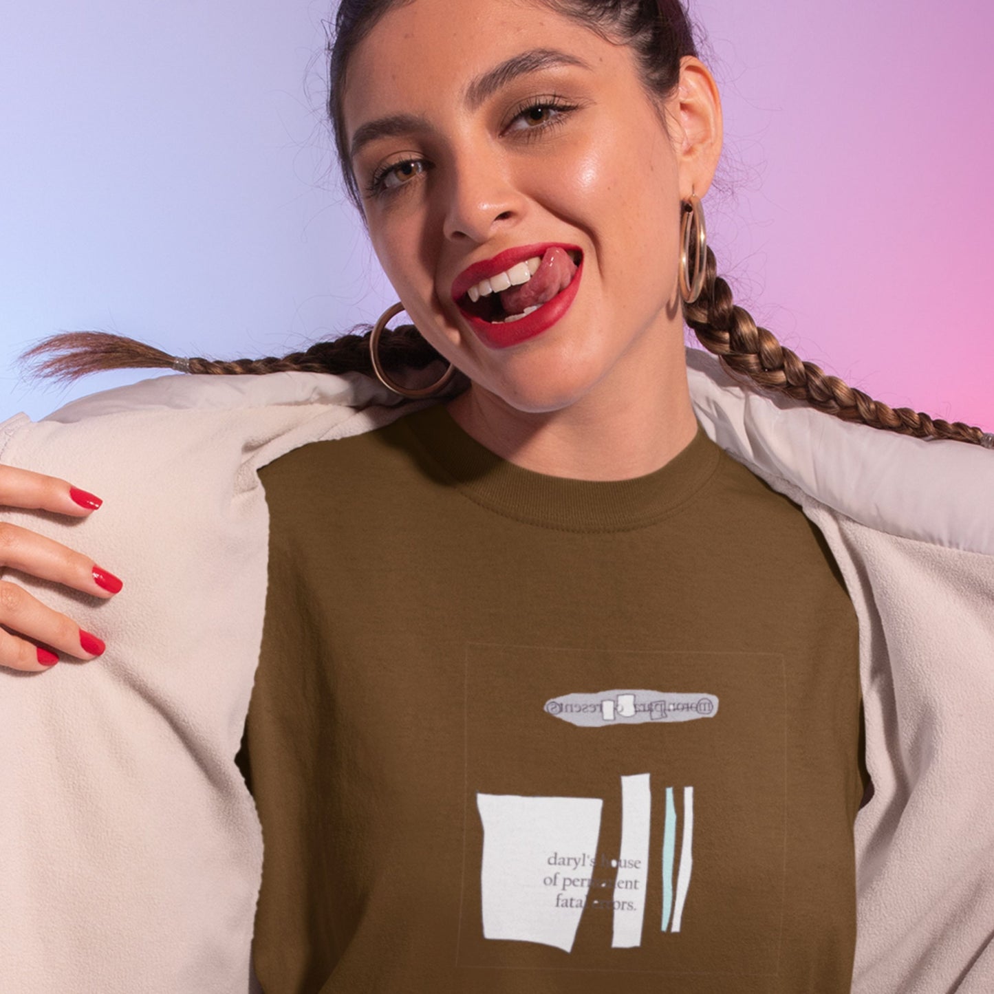 Woman wearing a brown t-shirt with text and graphics, smiling against a gradient background.