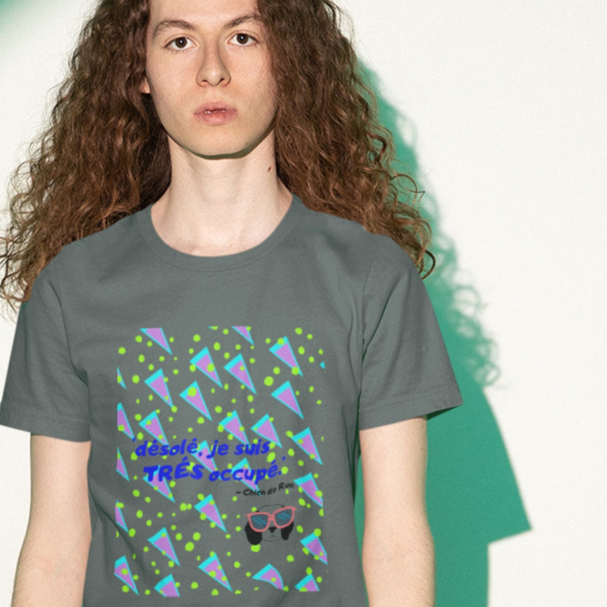 Person wearing a gray t-shirt with colorful geometric design and text.
