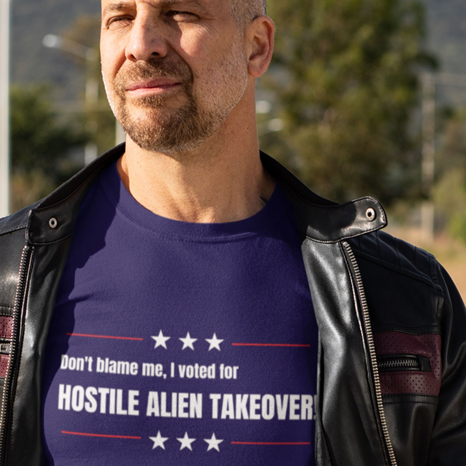 Man wearing a blue t-shirt with text outdoors.