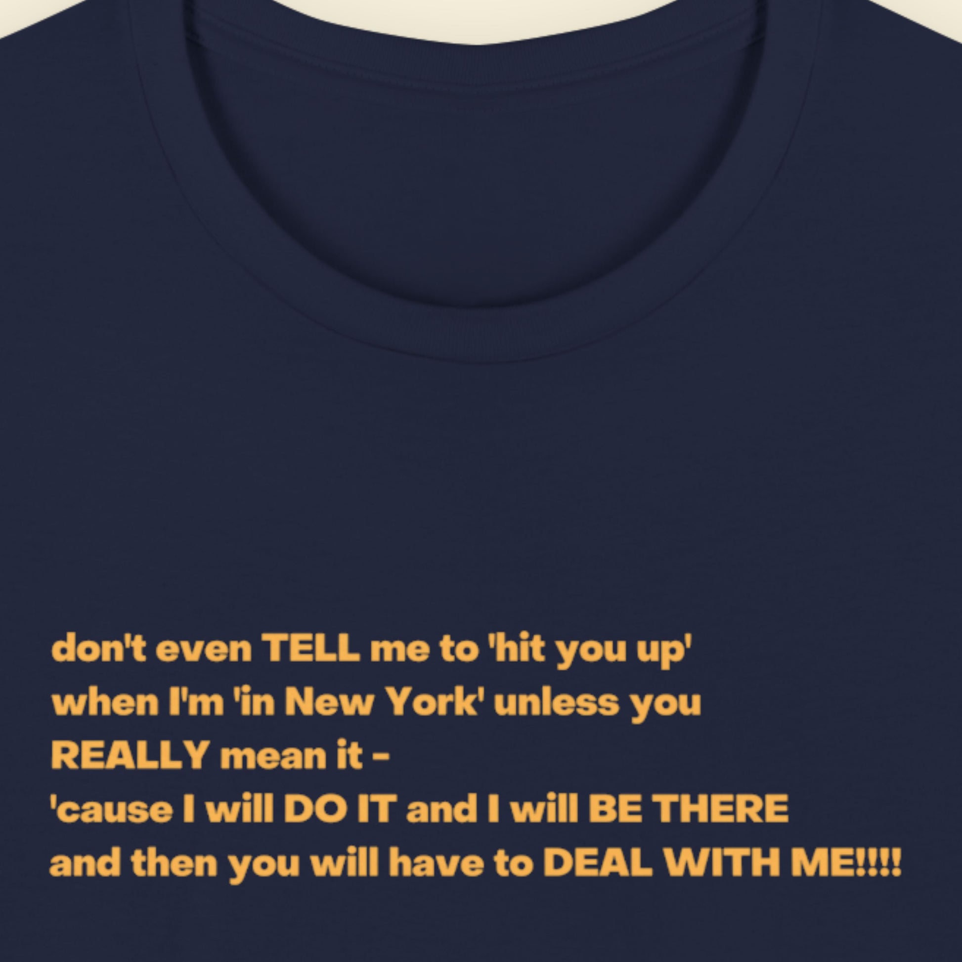 Navy blue t-shirt with humorous colorful text on a beige background.