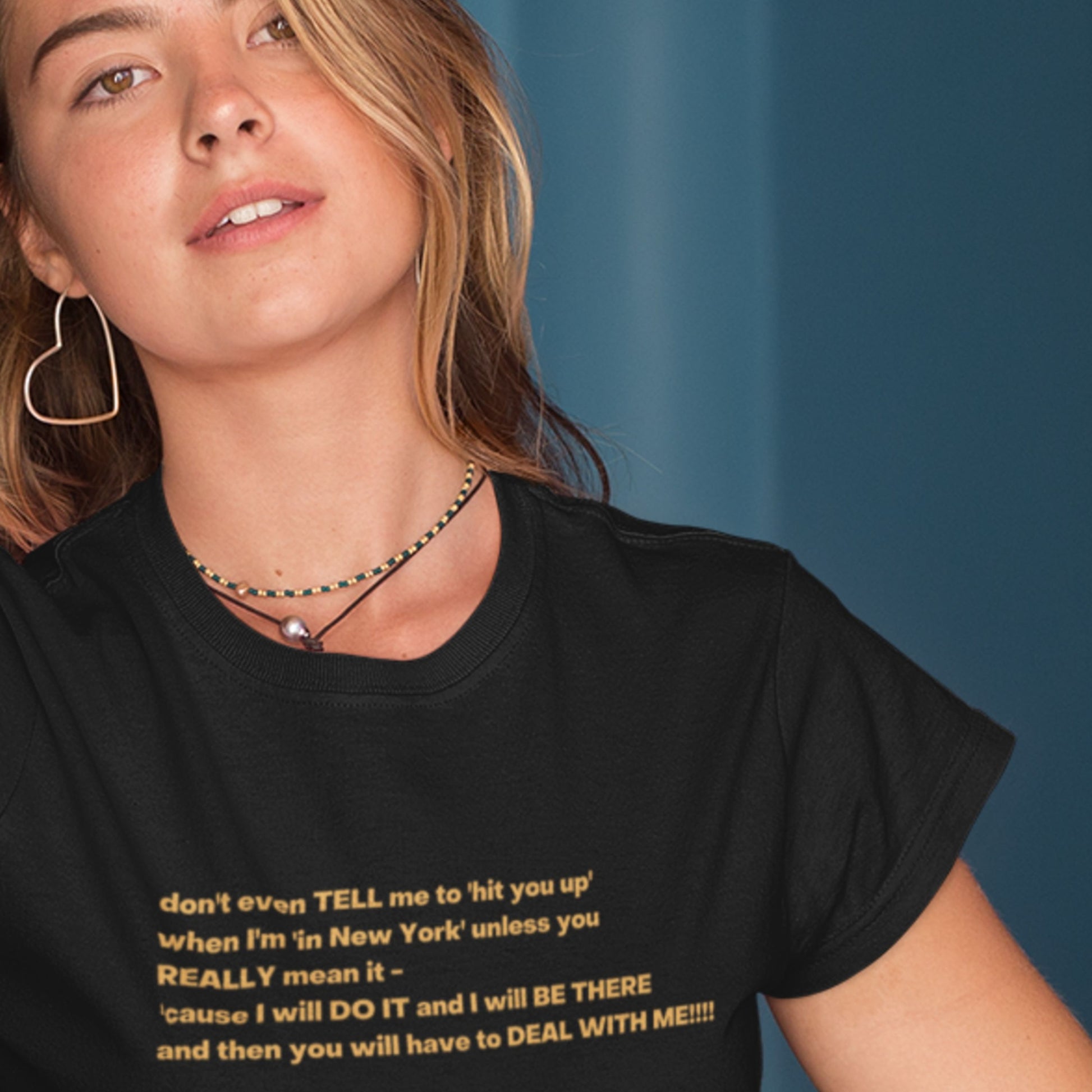 Person wearing a black t-shirt with yellow text against a blue background.