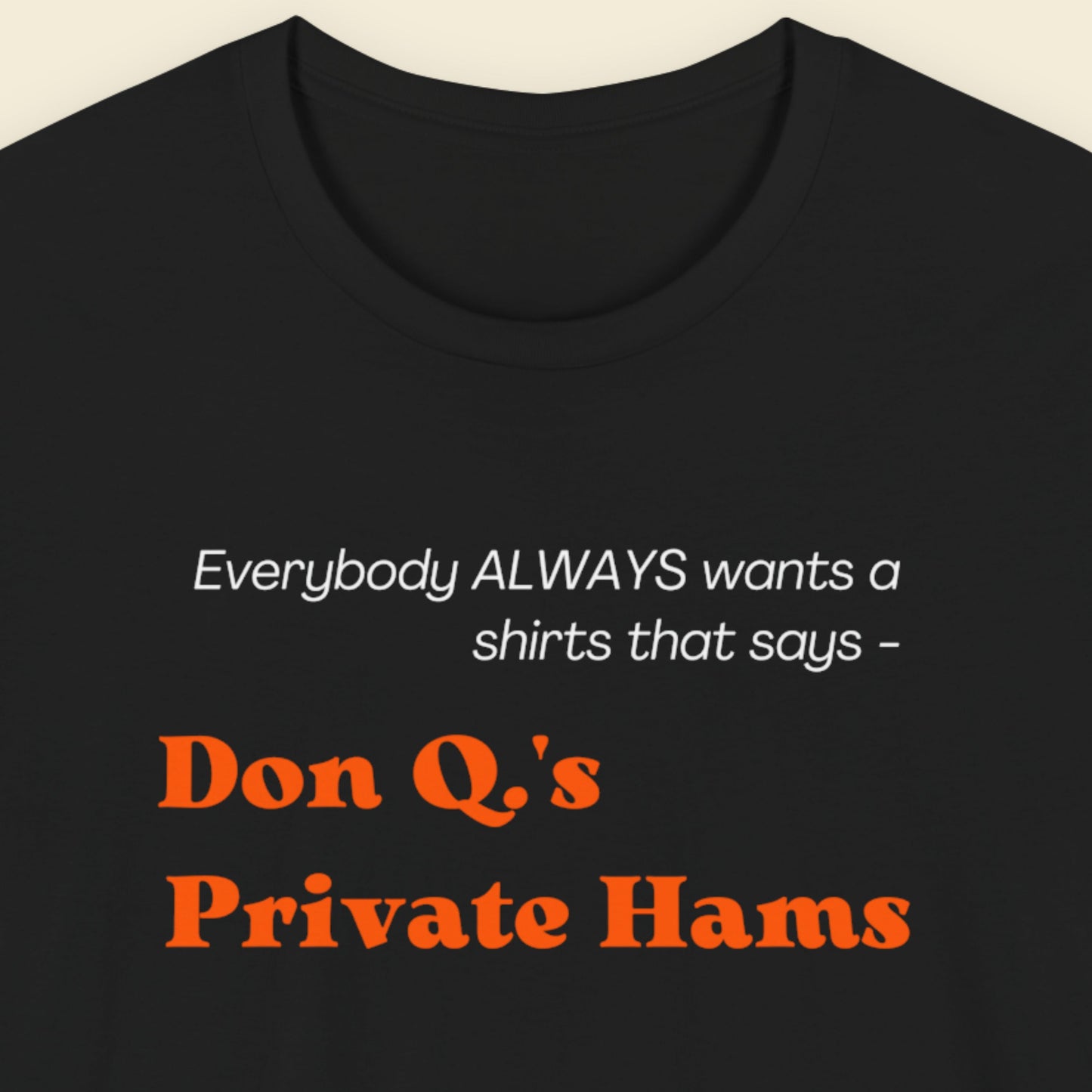 Black t-shirt with humorous colorful text on a beige background.